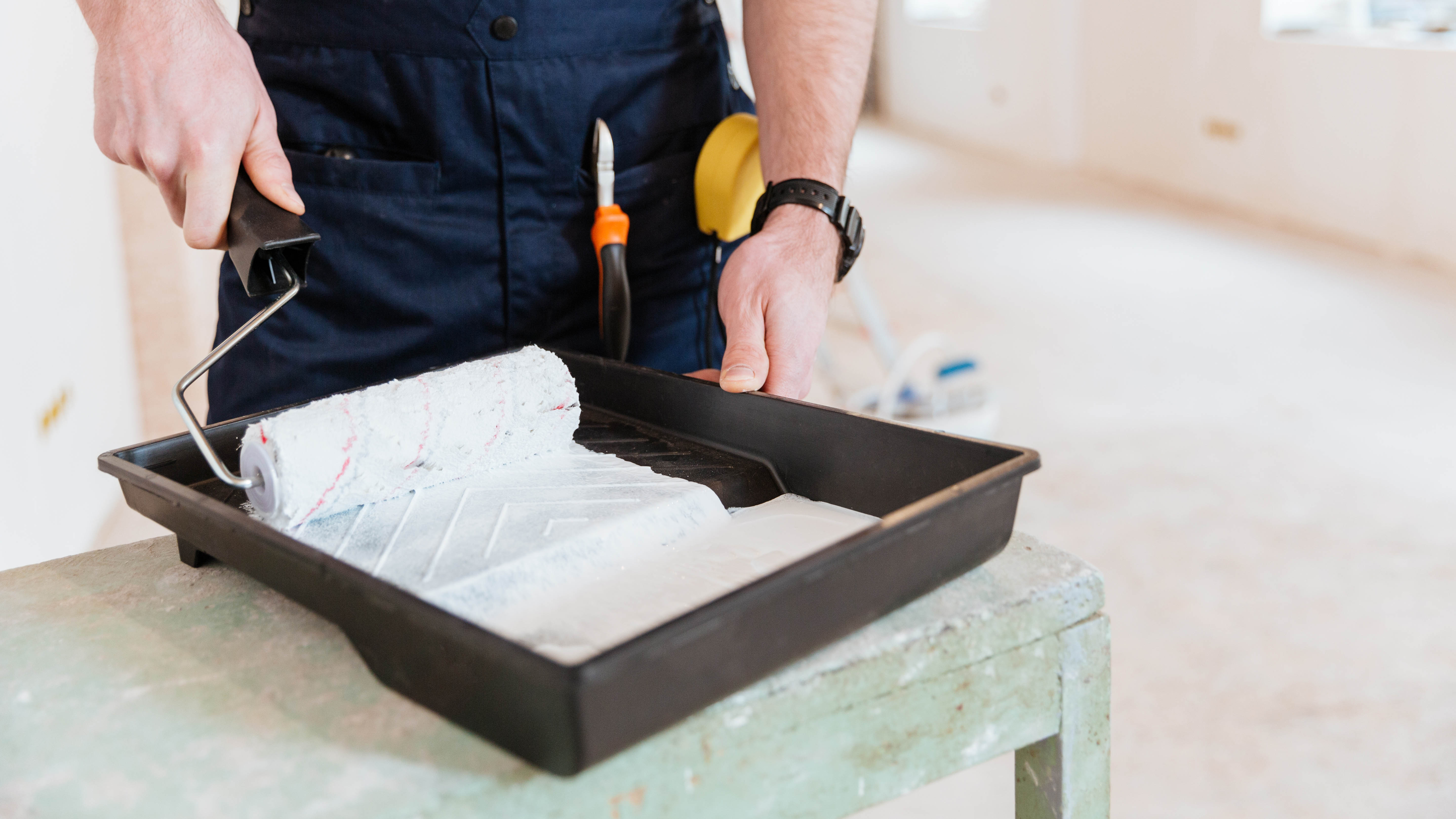 מגש מלא בצבע לבן ובו רולר על משטח שולחן