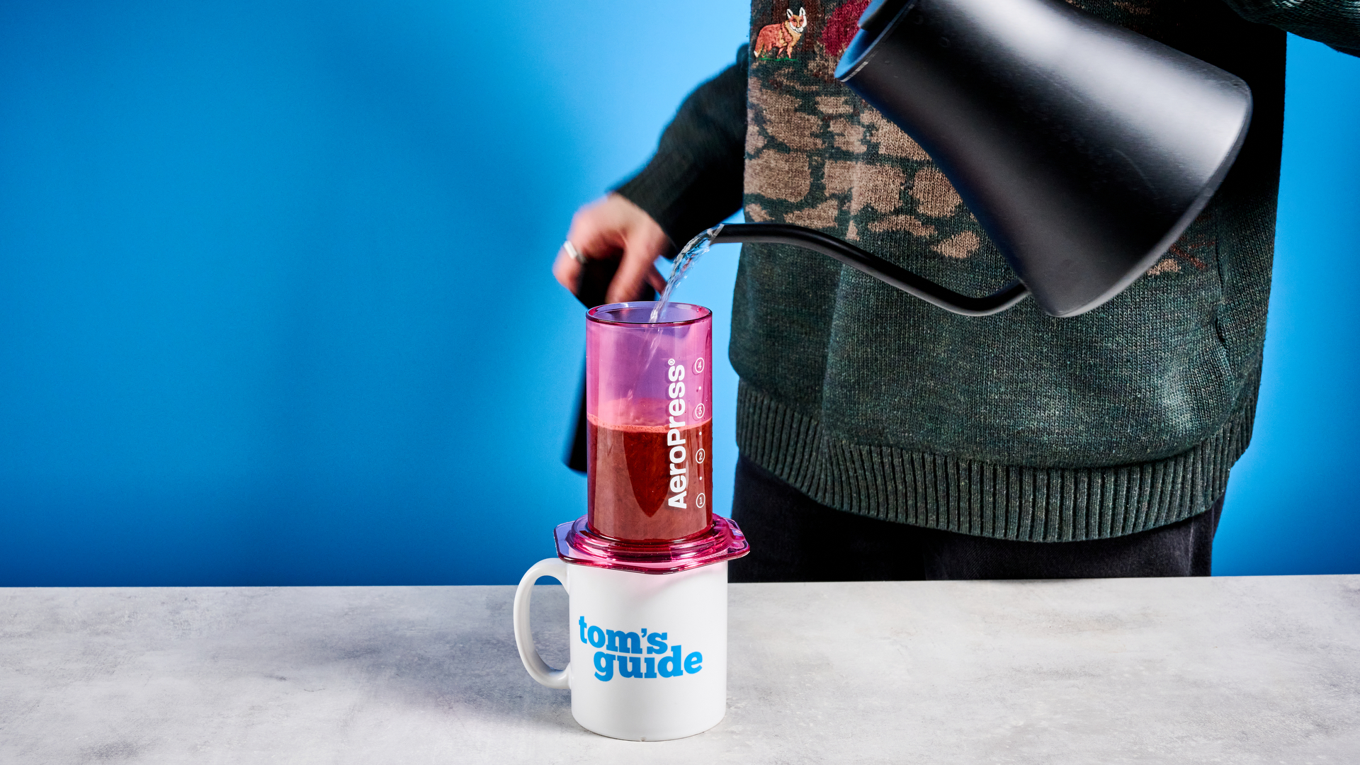 צבע ה-aeropress ברור בוורוד שצולם על רקע המדריך הכחול