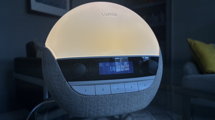 שעון הזריחה של Lumie Bodyclock Luxe 700FM מאיר חדר חשוך עם זוהר המחקה זריחה.