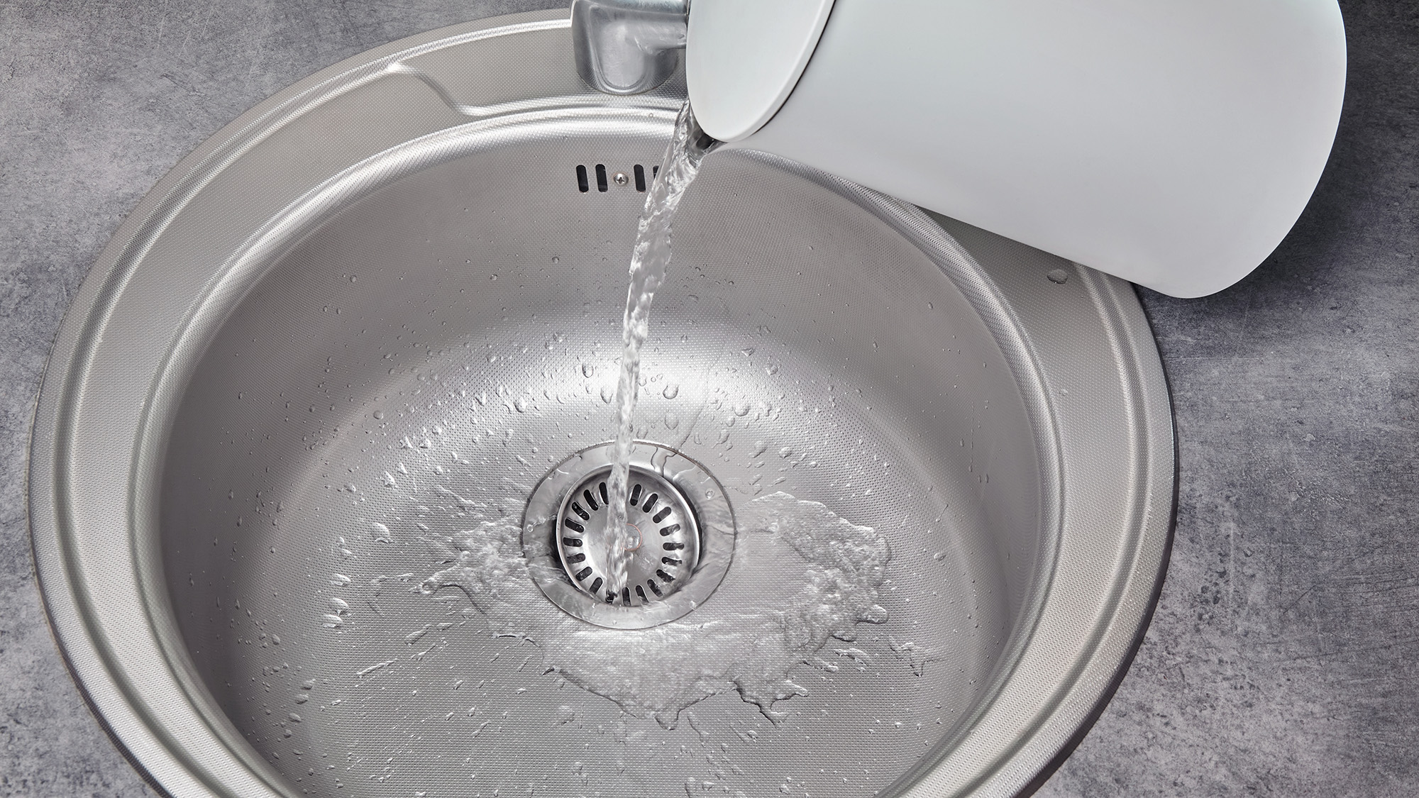 שפיכת מים רותחים מהקומקום למטה בכיור המטבח