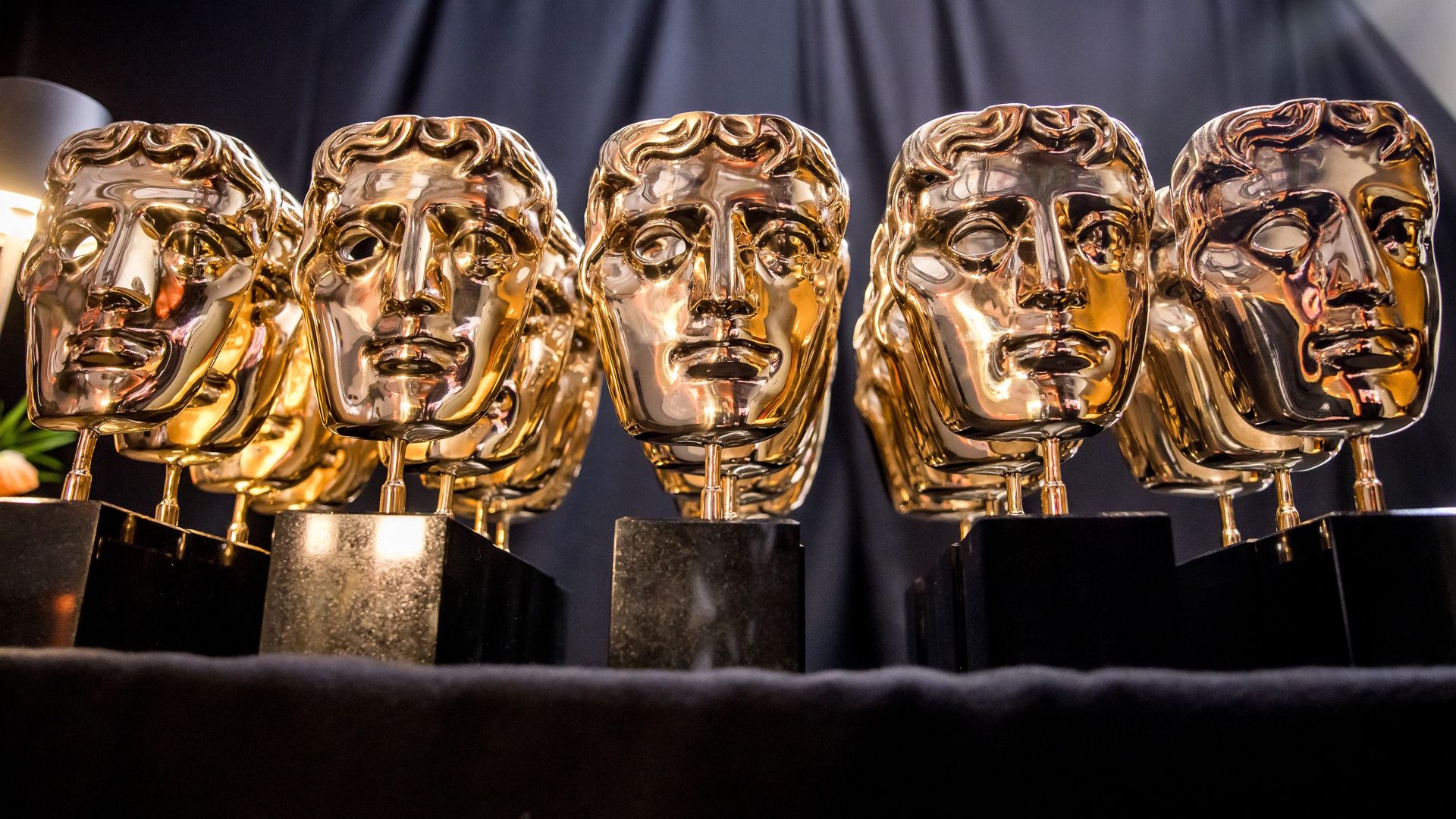 BAFTA Film Awards statues lined up in a row.