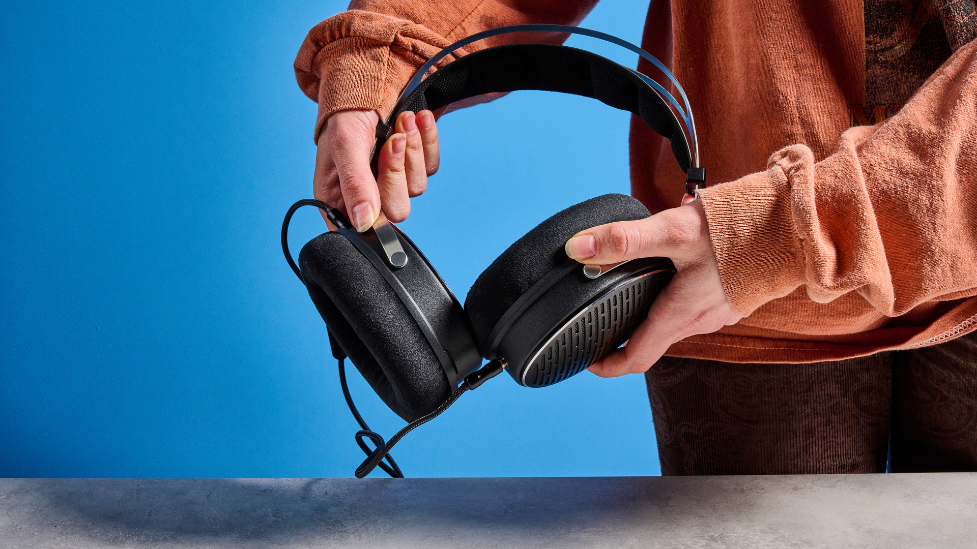 אוזניות ה-FiiO JT3 בשחור וכסף המוצגות על רקע המדריך הכחול של Tom's