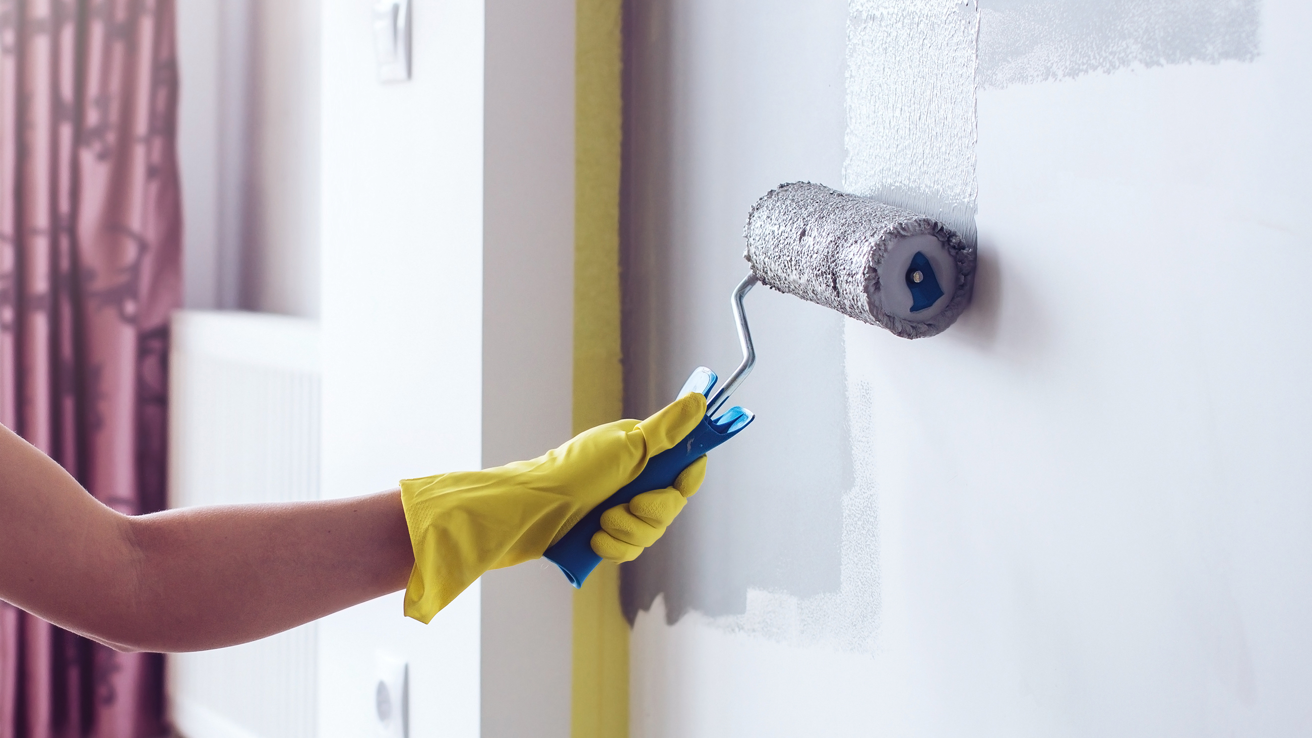 אישה מציירת קיר עם מברשת רולר