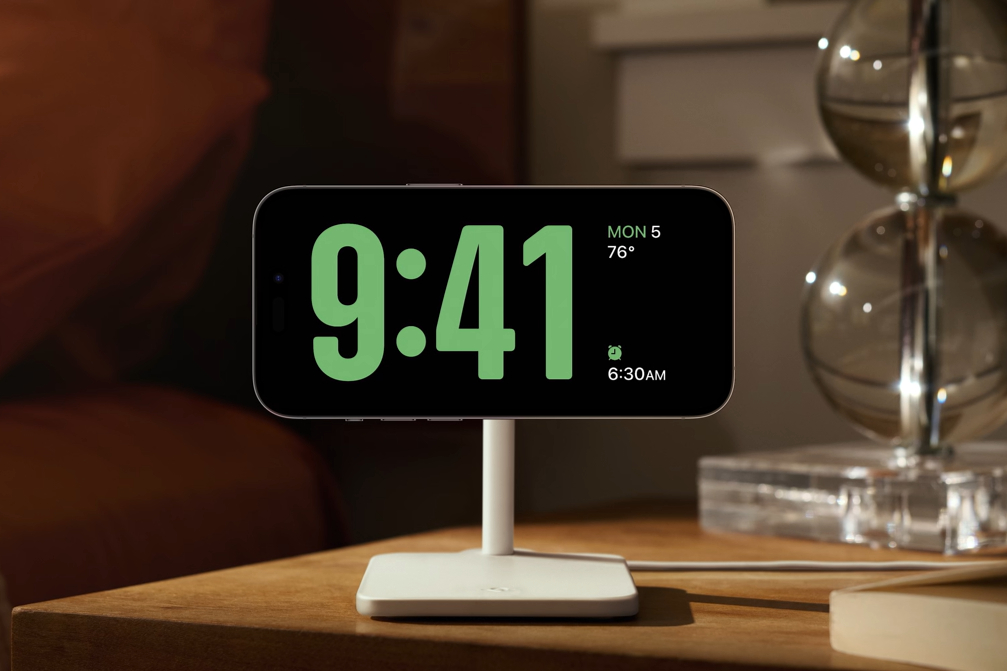 Apple iPhone על מטען MagSafe המציג מצב המתנה של iOS 17.