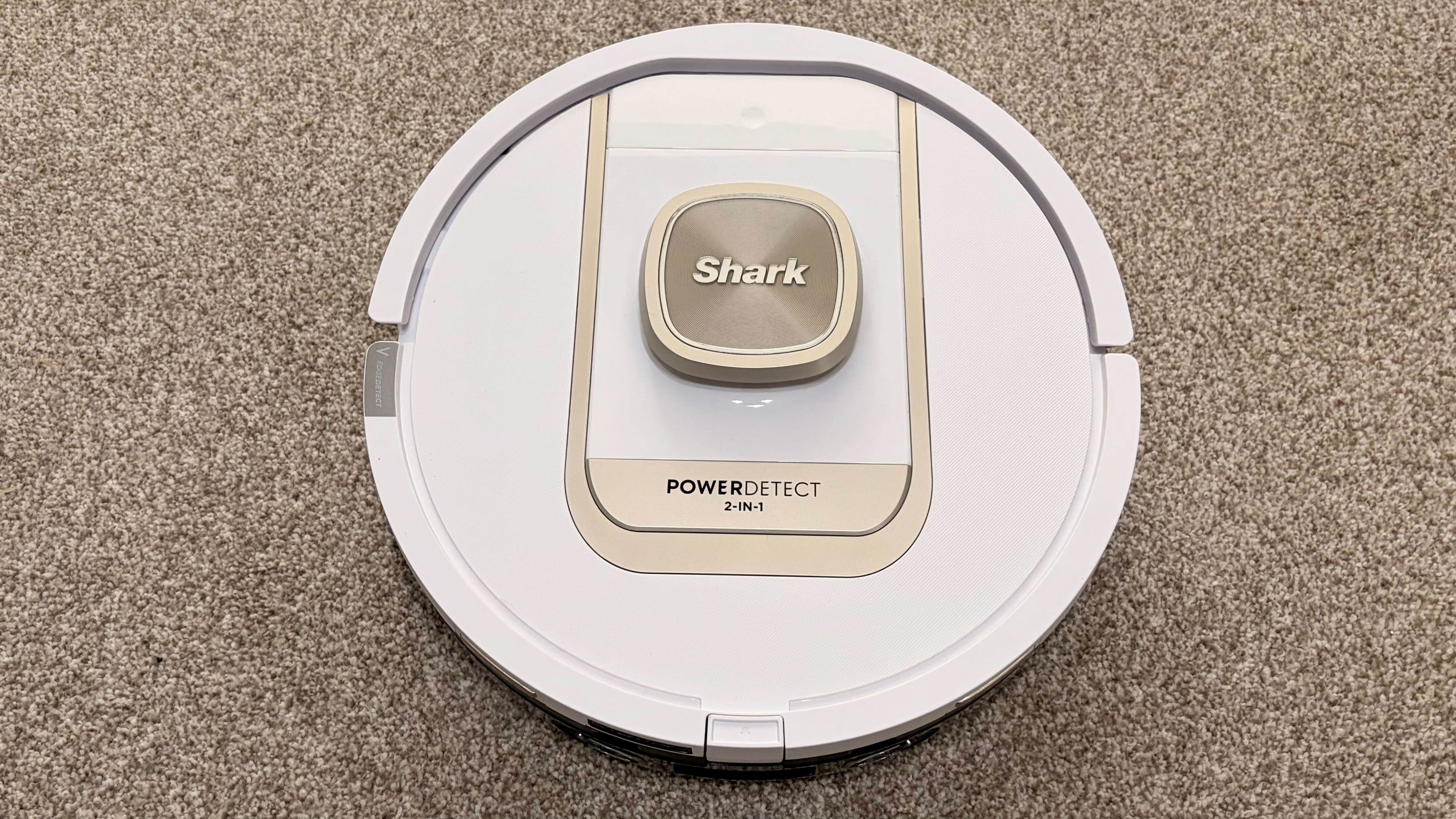 Shark PowerDetect 2-in-1 ThermaCharged NeverTouch צולם על שטיח עם תחנת עגינה