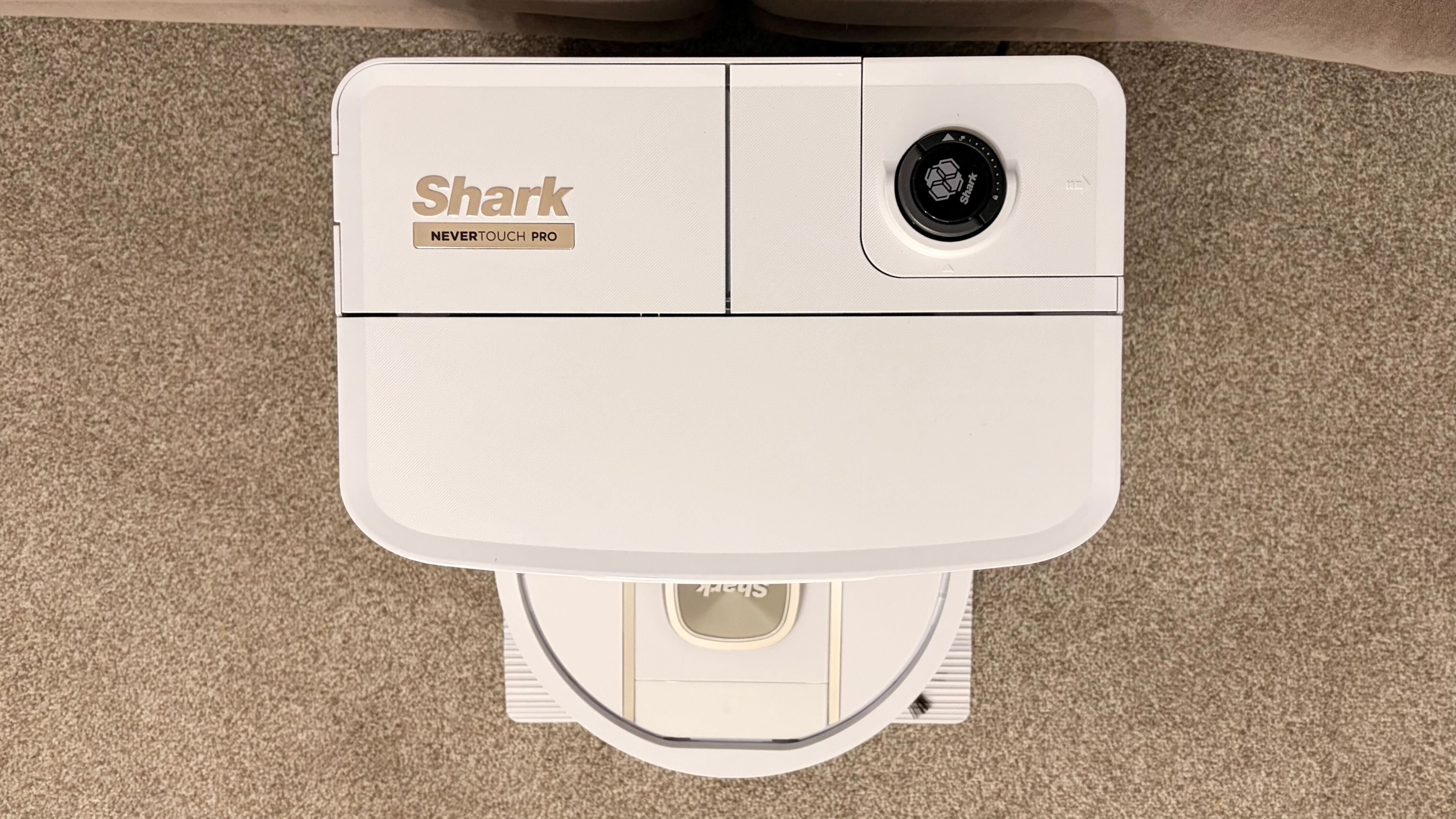 Shark PowerDetect 2-in-1 ThermaCharged NeverTouch צולם על שטיח עם תחנת עגינה