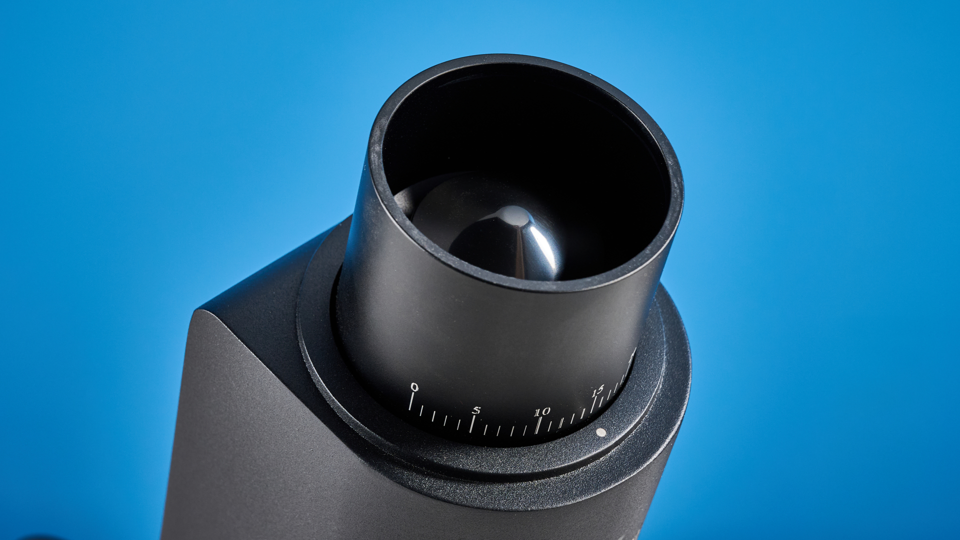 מטחנת הקפה של wirsh geimori gu38 בשחור עם מכסה קופר אגוז שצולמה על רקע המדריך הכחול של טום