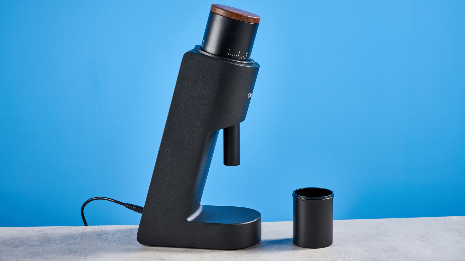 מטחנת הקפה של wirsh geimori gu38 בשחור עם מכסה קופר אגוז שצולמה על רקע המדריך הכחול של טום