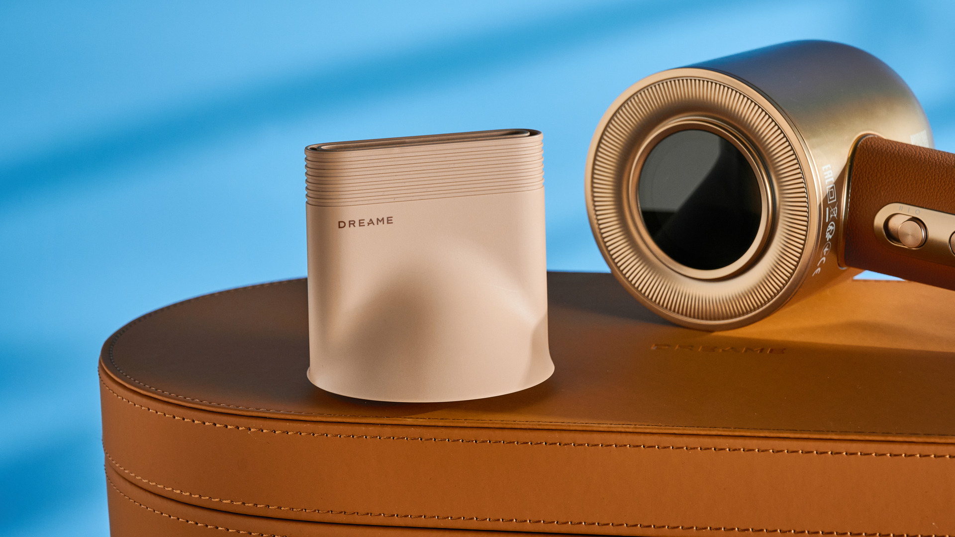 מייבש השיער dreame miracle pro בצבע זהב המציג את קופסת האחסון על רקע המדריך הכחול, עם ארבע חרירי החיבור כולל שתי פיות ייבוש, מפזר, והאיילוף המעופף