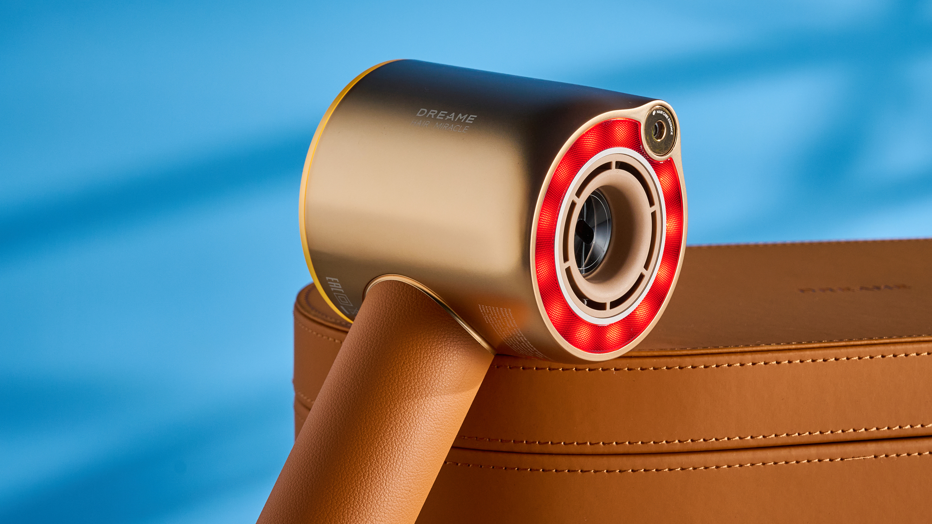 מייבש השיער dreame miracle pro בצבע זהב המציג את קופסת האחסון על רקע המדריך הכחול, עם ארבע חרירי החיבור כולל שתי פיות ייבוש, מפזר, והאיילוף המעופף