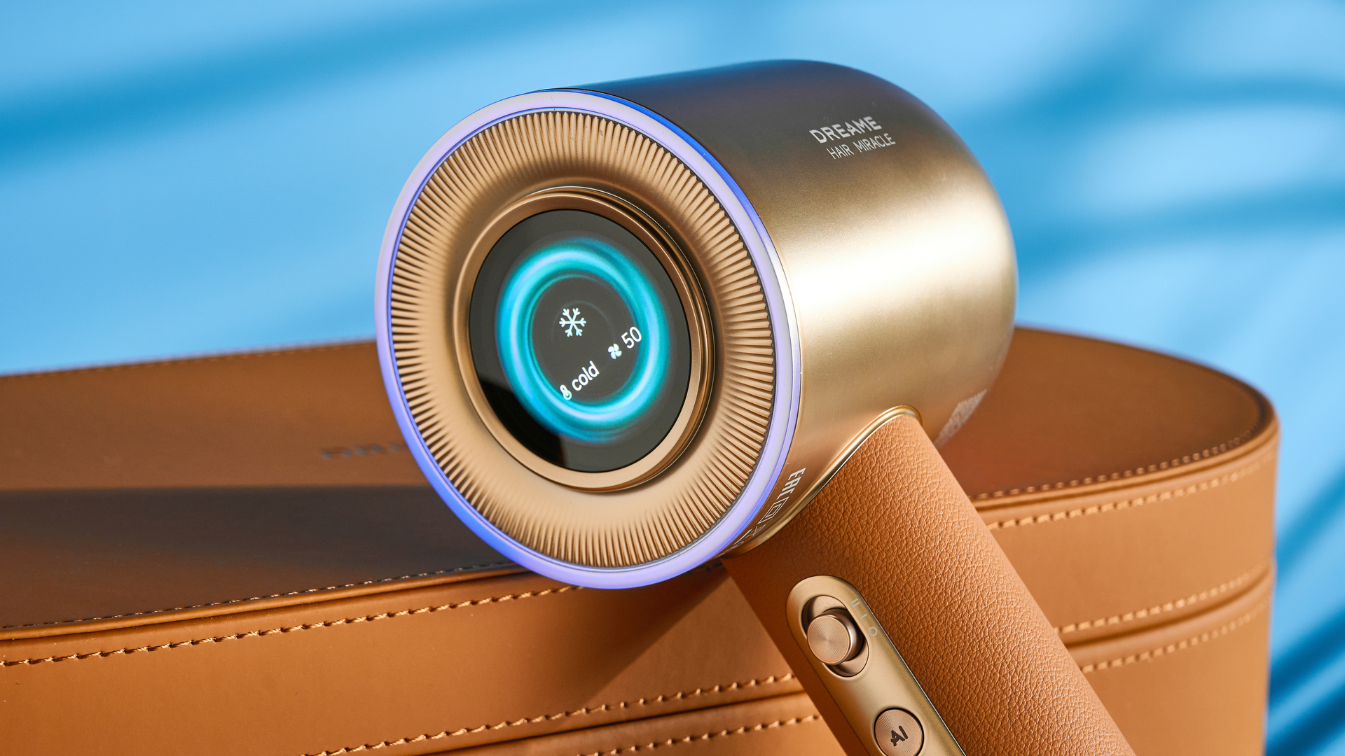 מייבש השיער dreame miracle pro בצבע זהב המציג את קופסת האחסון על רקע המדריך הכחול, עם ארבע חרירי החיבור כולל שתי פיות ייבוש, מפזר, והאיילוף המעופף