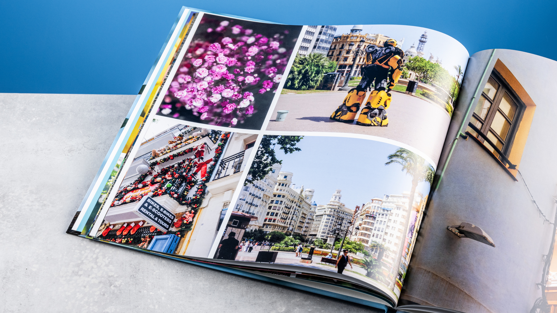 דפי ספר התמונות של Vistaprint שצולמו על שולחן מול רקע כחול