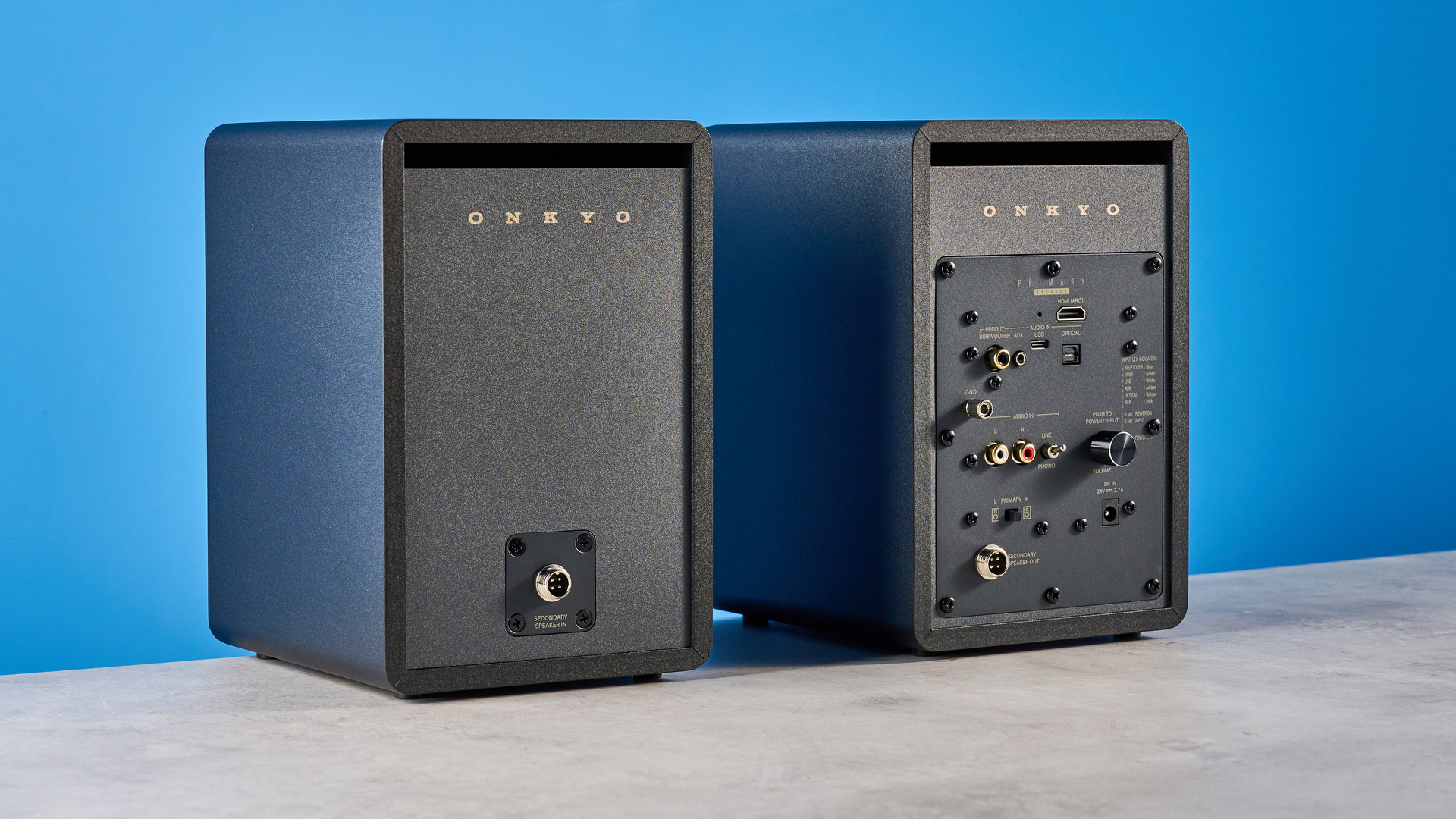 רמקולי מדף ספרים Onkyo GX-30ARC מצולמים על רקע כחול