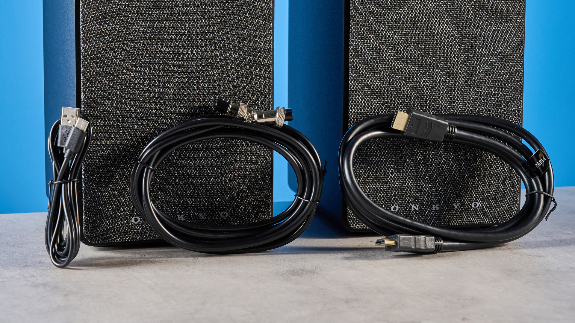 רמקולי מדף ספרים Onkyo GX-30ARC מצולמים על רקע כחול