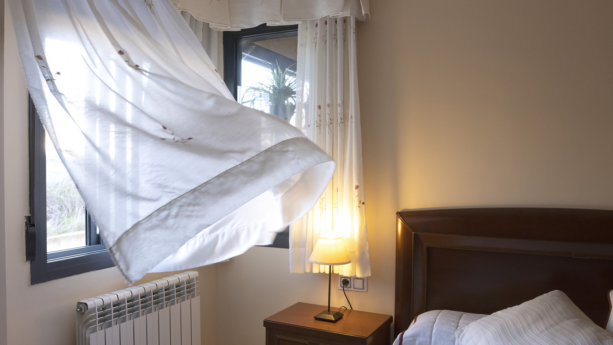 חלון פתוח עם רוח נושבת בחדר השינה