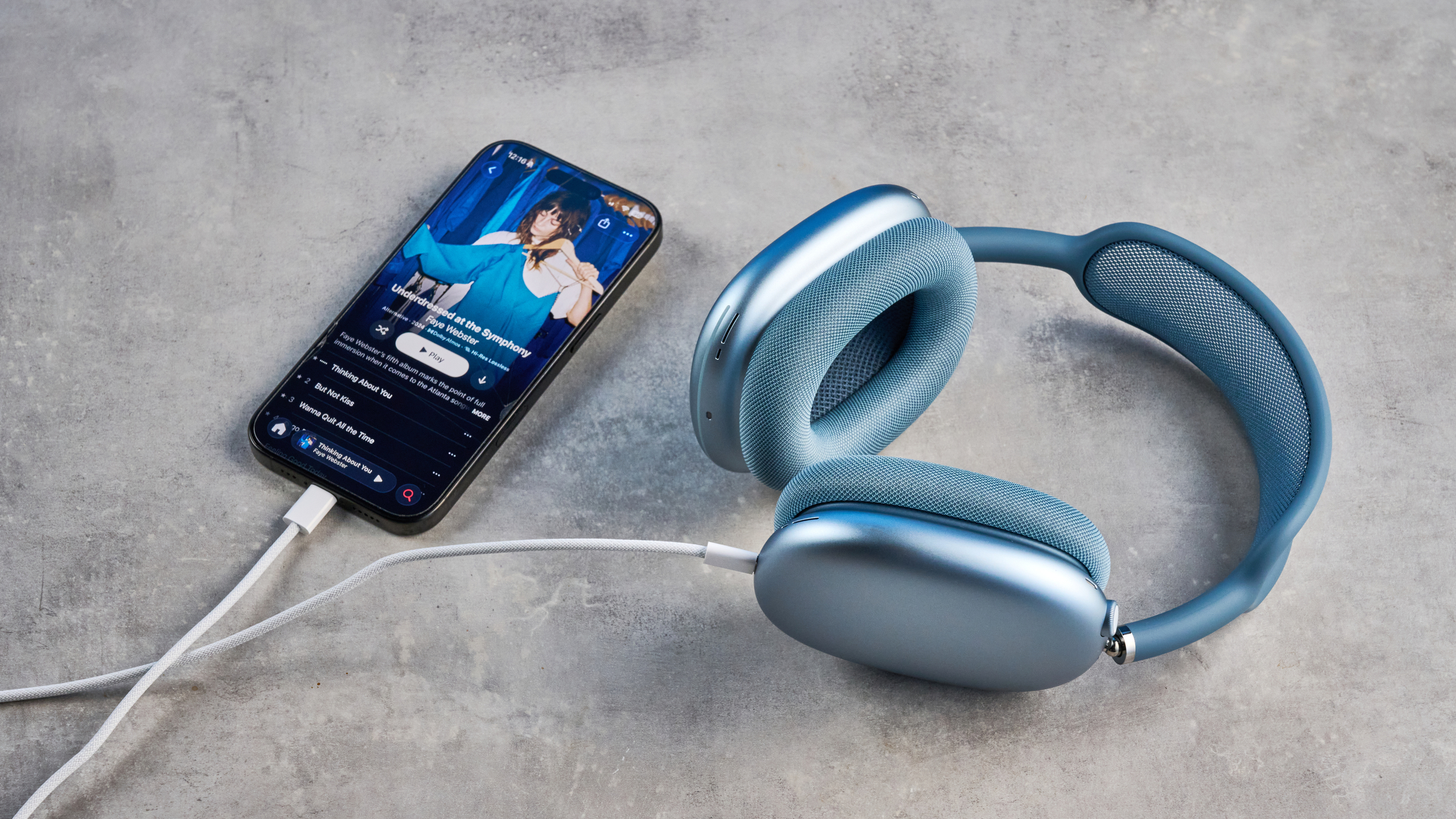 ה-apple airpods max 2 בכחול מצולמים על רקע מדריך כחול, מציגים את סרט הרשת, כוסות אוזניים מאלומיניום באנודיום, תיק נשיאה ובקרות