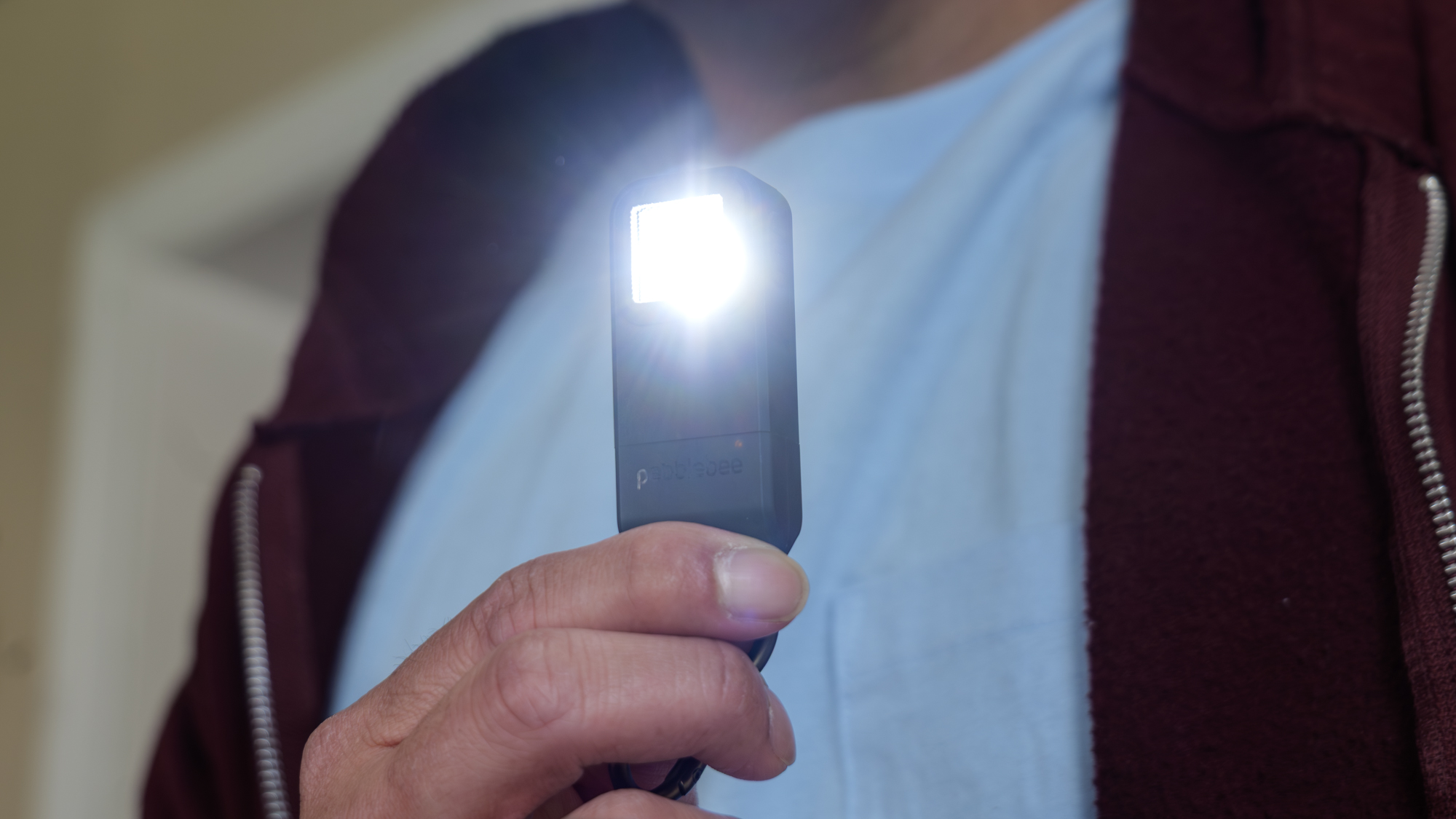 Pebblebee Halo החזיקה ביד עם פנס דולק.