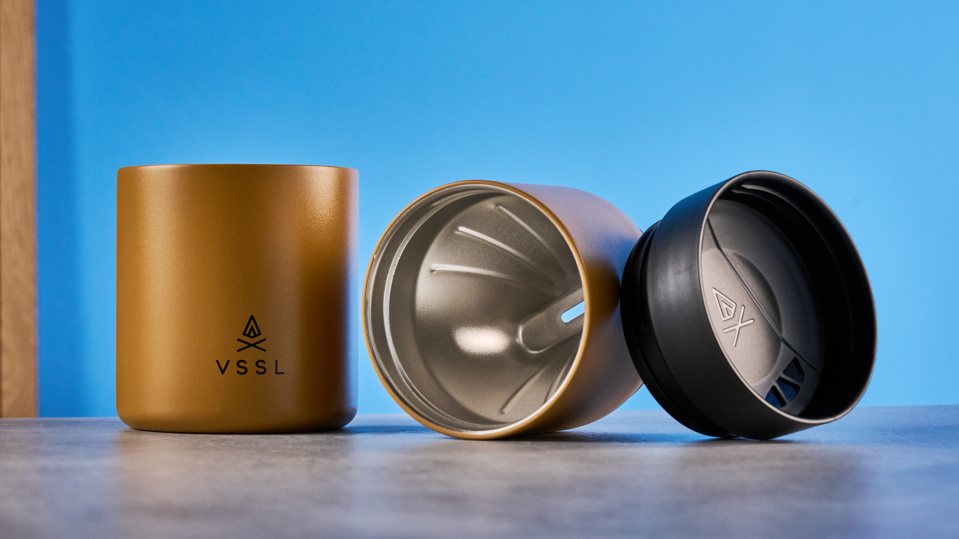 סט VSSL Nest Pour Over Coffee בזהב שצולם על רקע המדריך הכחול