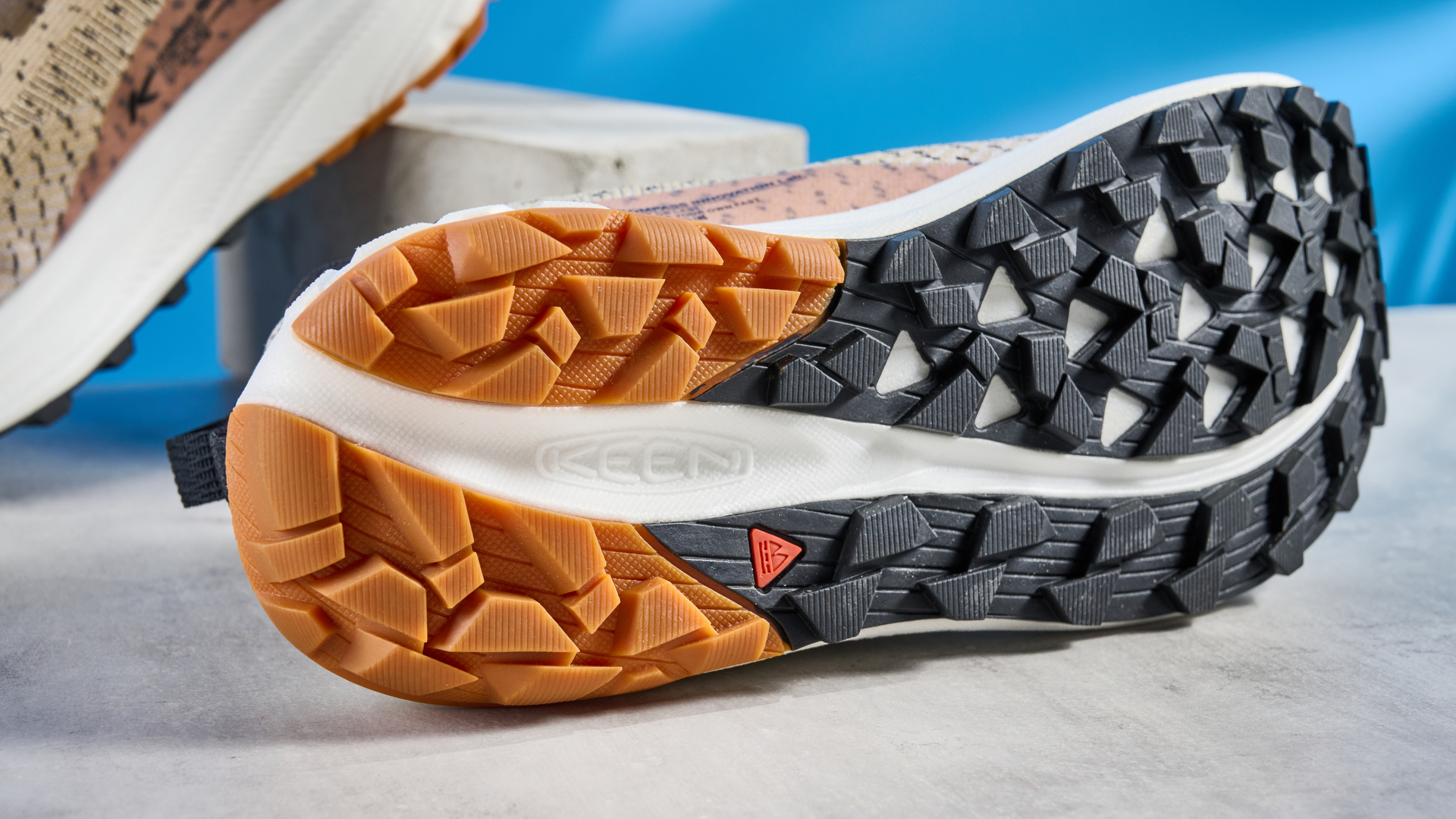 נעלי השביל החריפות בחום, שחור ובז' שצולמו על רקע המדריך הכחול של טום