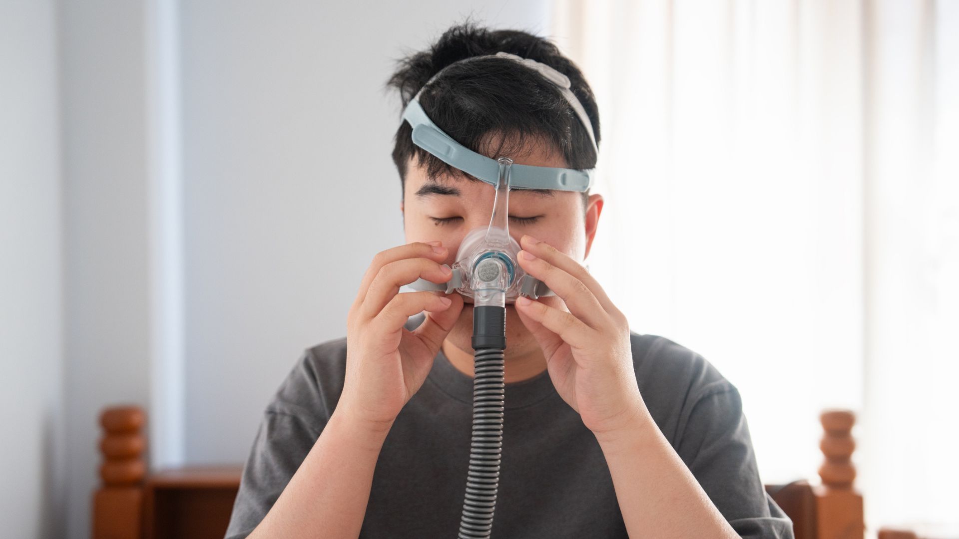 גבר שמתאים מסכת CPAP כדי לעזור לדום נשימה המרכזי שלו בשינה