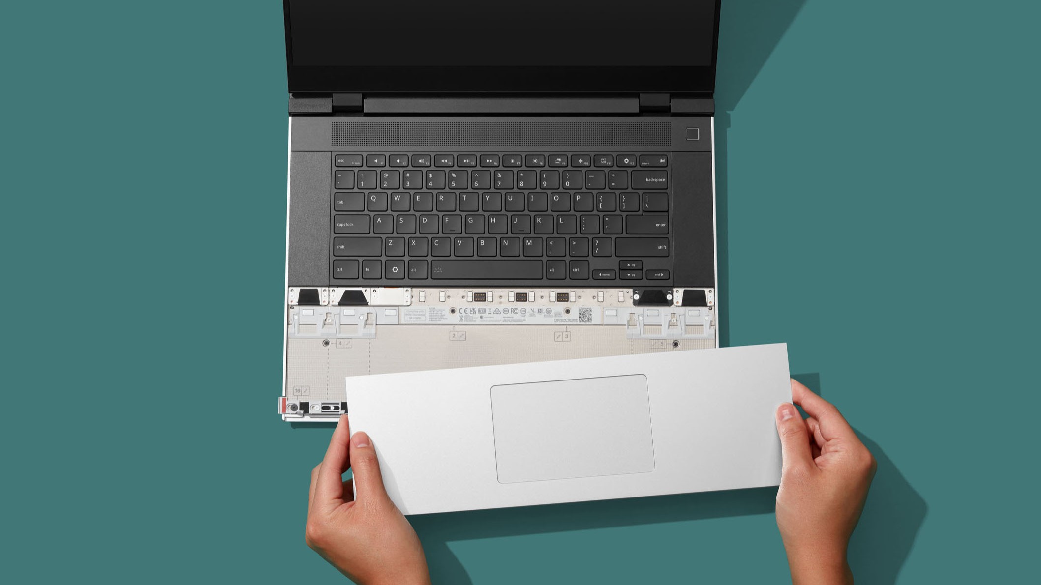 אדם שמתקין את לוח המגע ההאפטי החדש של Framework במחשב הנייד 16