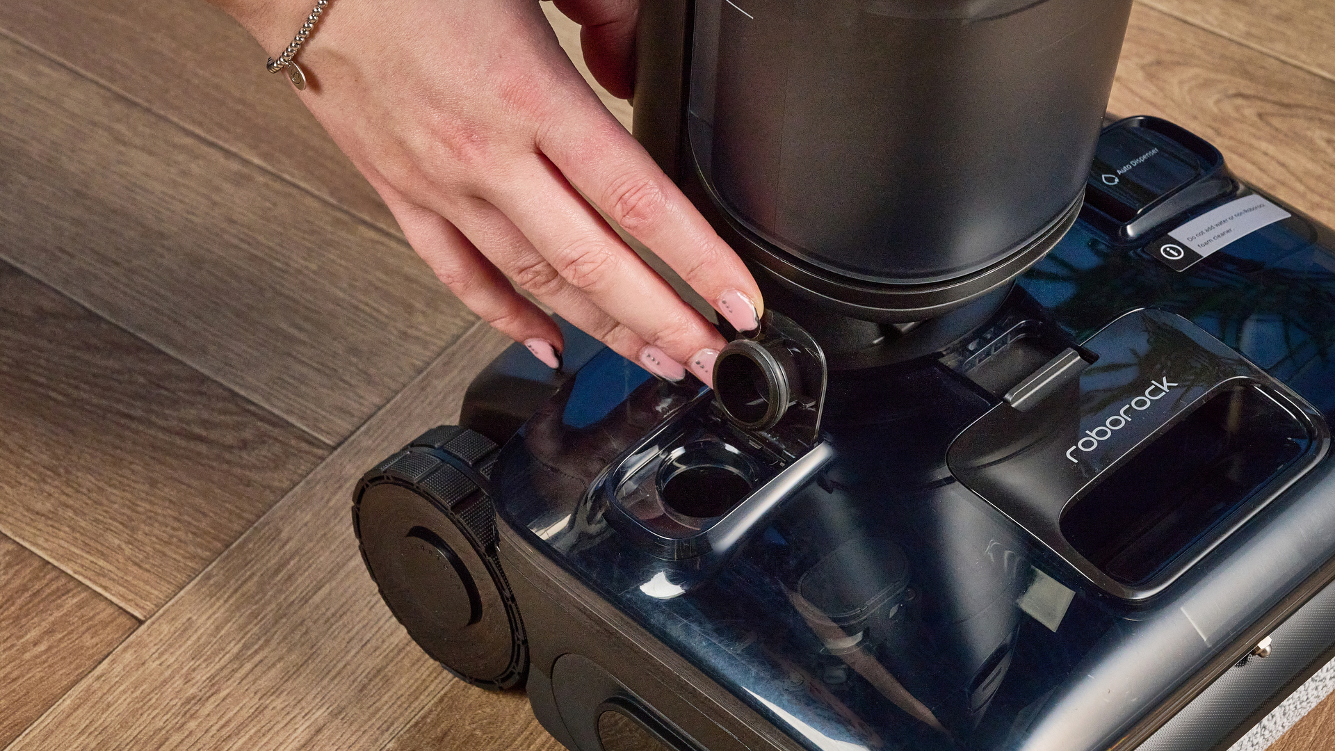 מיכל מים נקיים של ה-Roborock F25 ACE Pro שצולם על רצפת עץ חומה