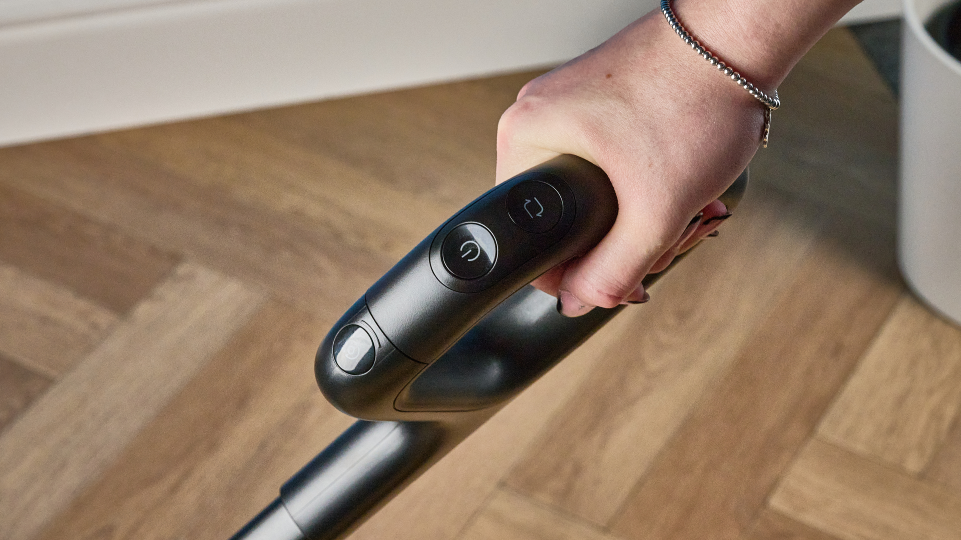 ידית של Roborock F25 ACE Pro מצולמת על רצפת עץ חומה