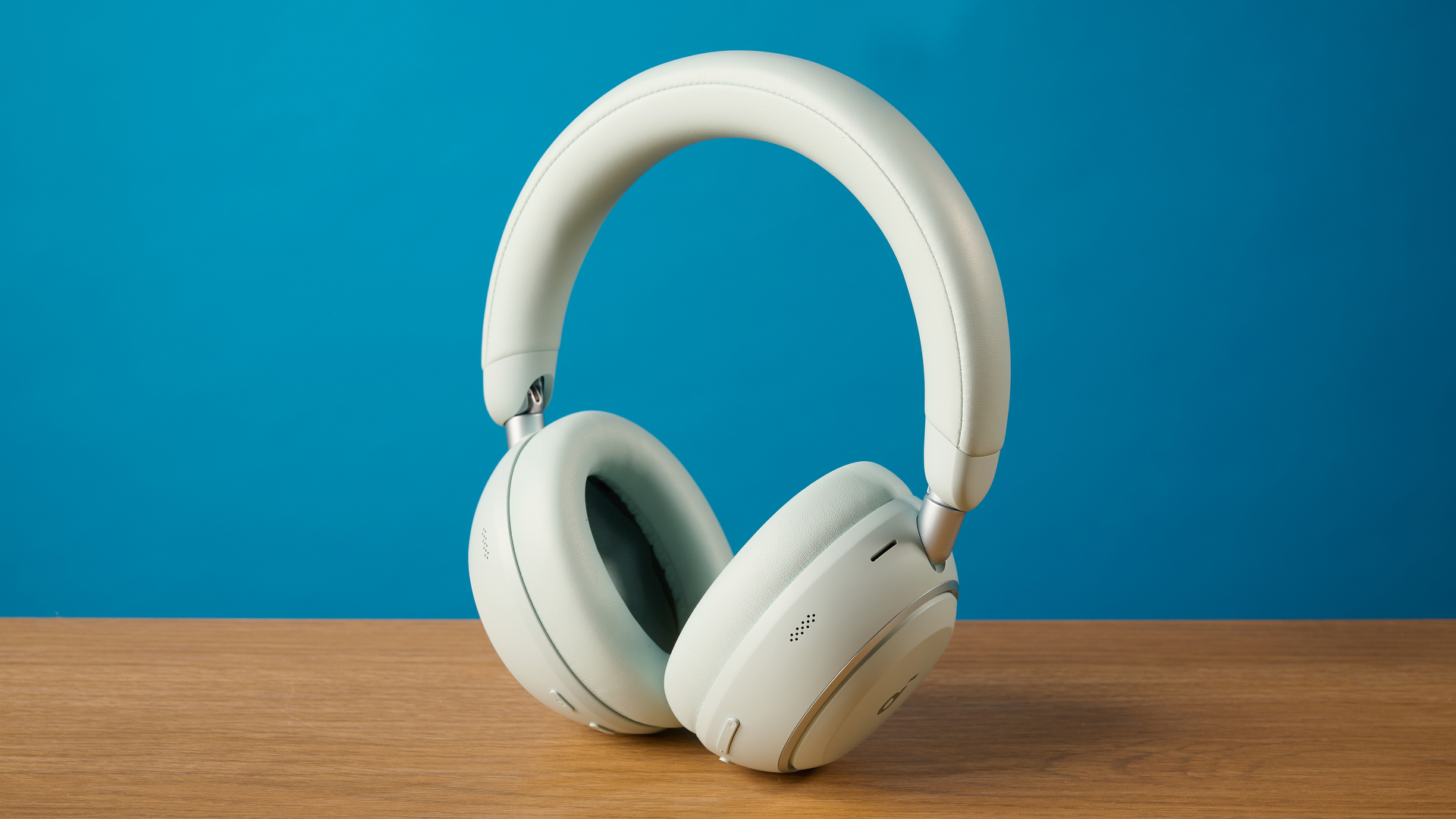 the soundcore space 2 אוזניות בלבן שצולמו על רקע מדריך טום כחול