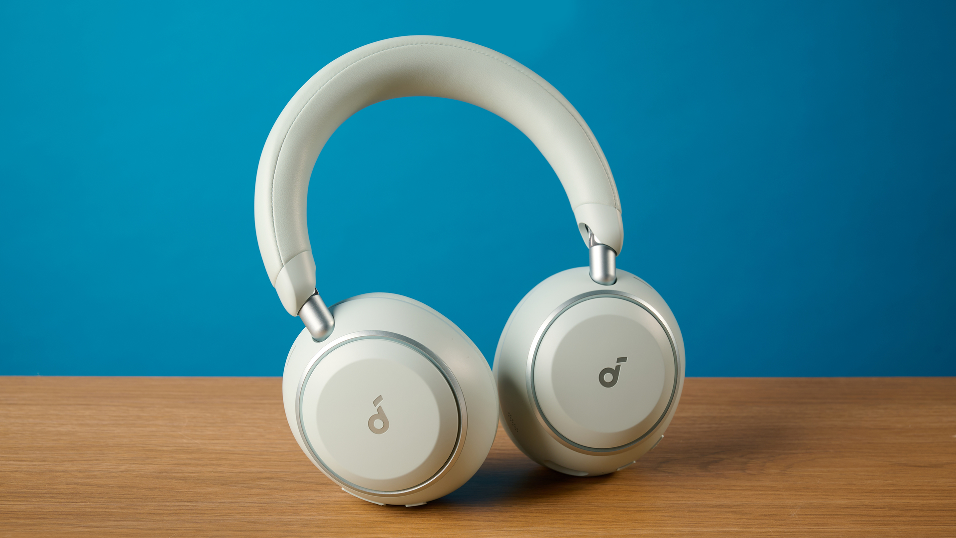 the soundcore space 2 אוזניות בלבן שצולמו על רקע מדריך טום כחול
