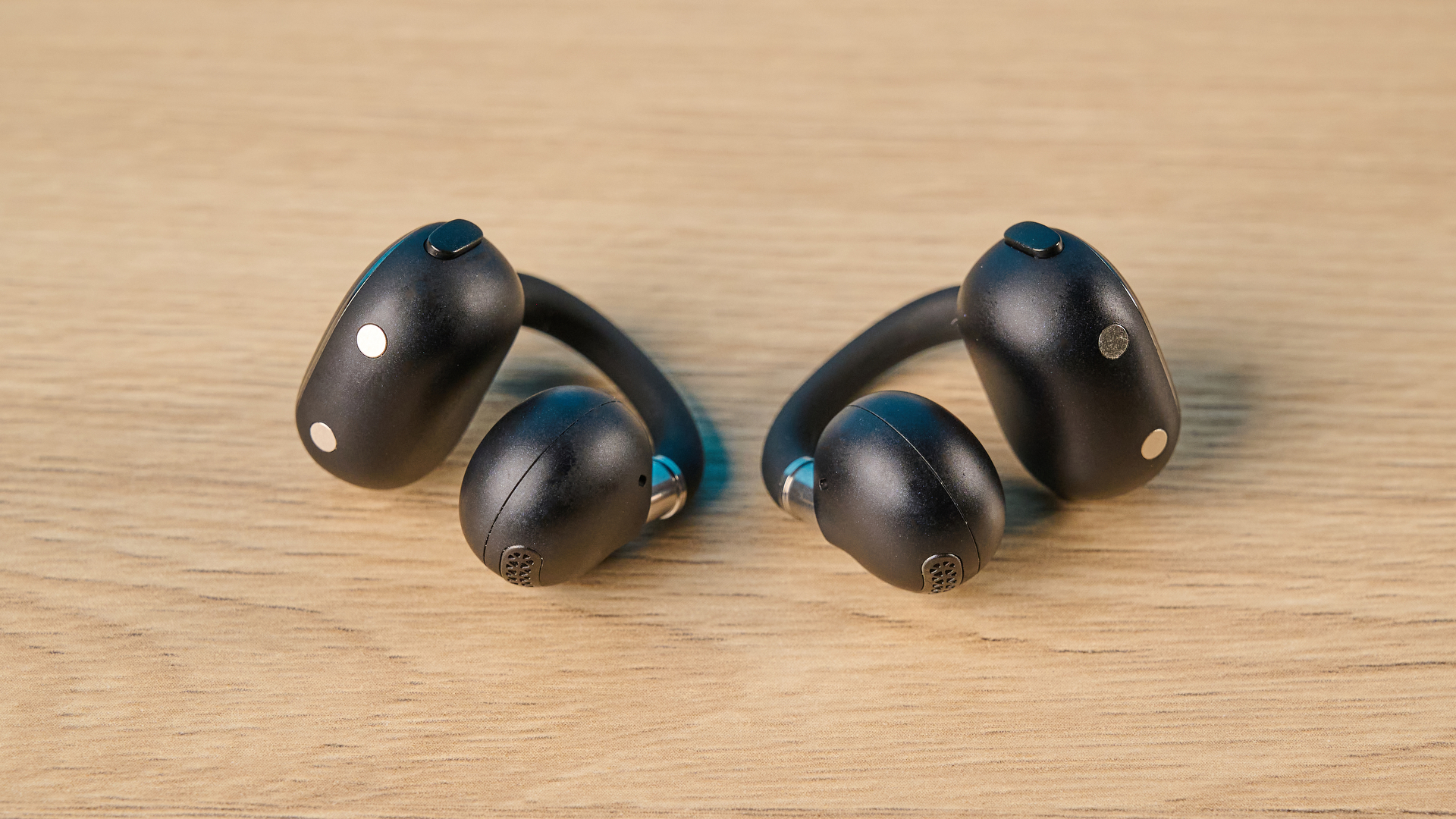 EarFun Clip 2 בשחור על שולחן מצולם מול רקע כחול