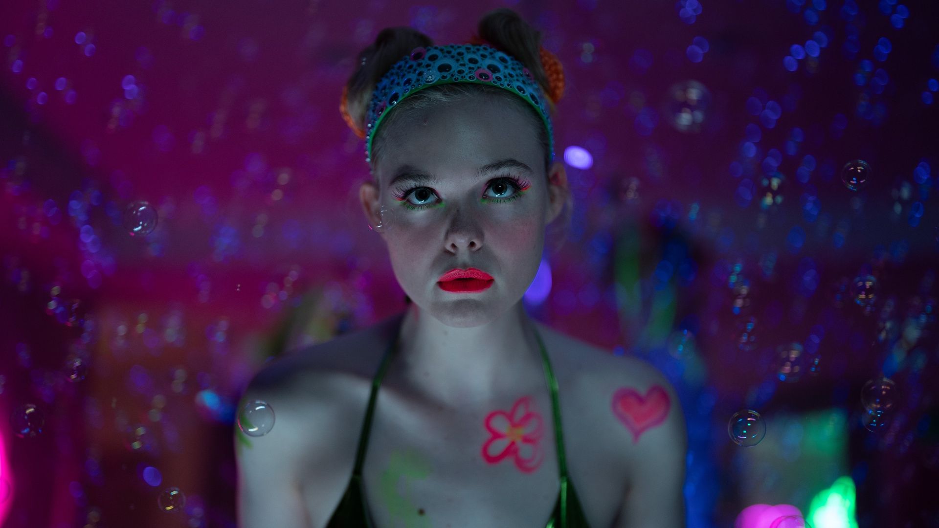 A close up of Elle Fanning wearing bright red lipstick in a scene from Apple TV's 'Margo’s Got Money Trouble'.