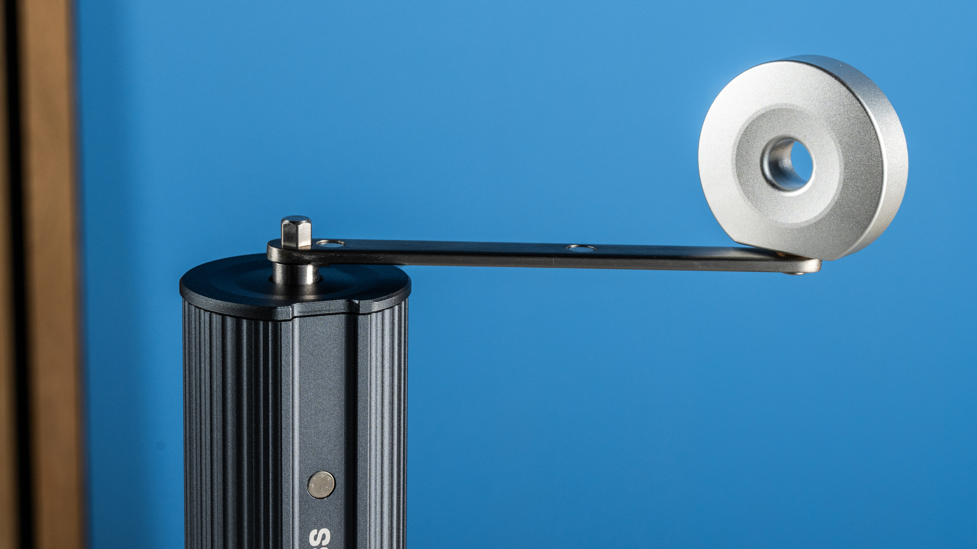 מטחנת הקפה הידנית של Aeropress בצבעי אפור וכסף על רקע הכחול של המדריך