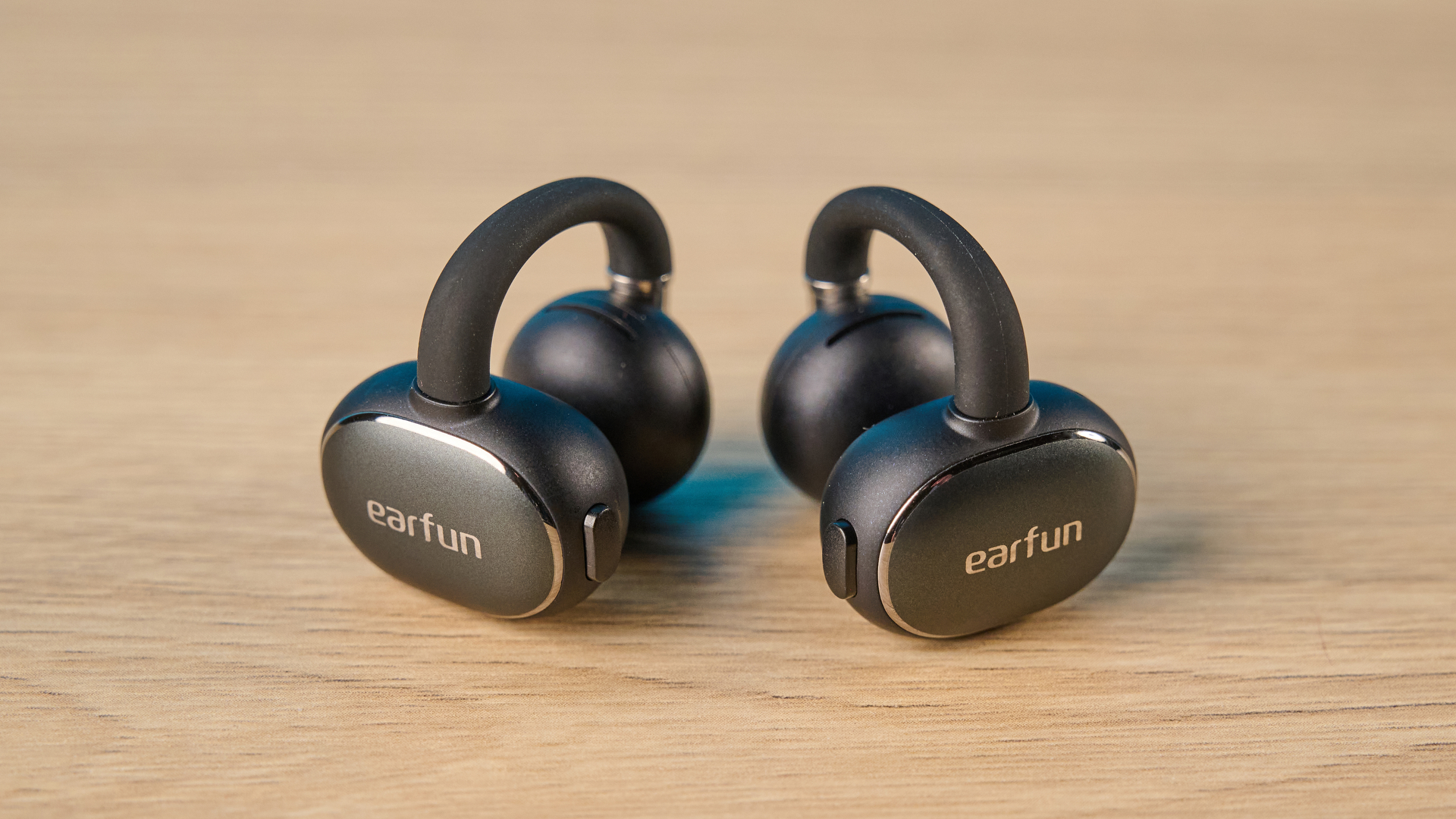 EarFun Clip 2 בצבע שחור על שולחן עץ