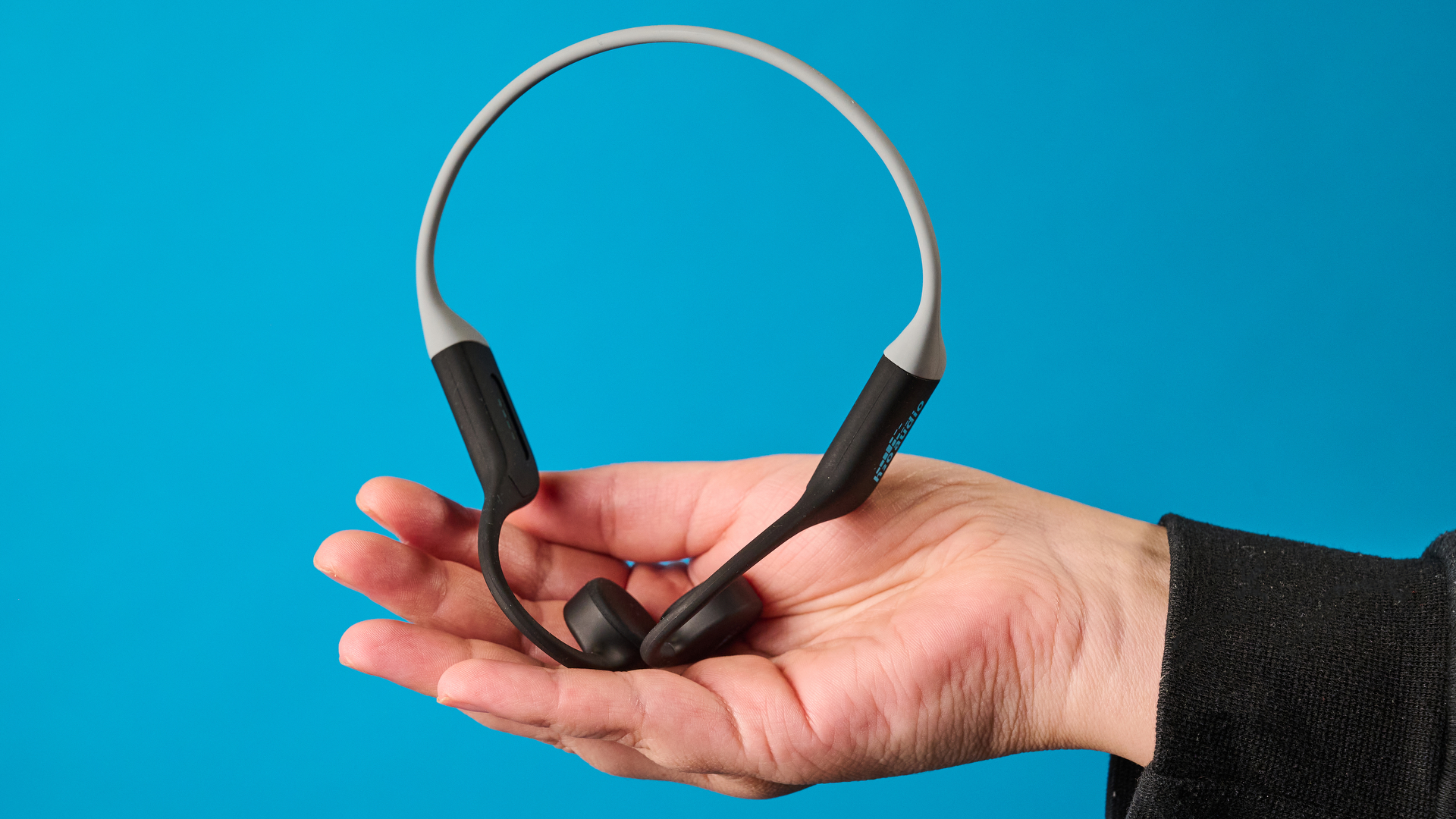 אוזניות ה-h2o audio tri run bone conduction שצולמו על רקע כחול של Tom's guide