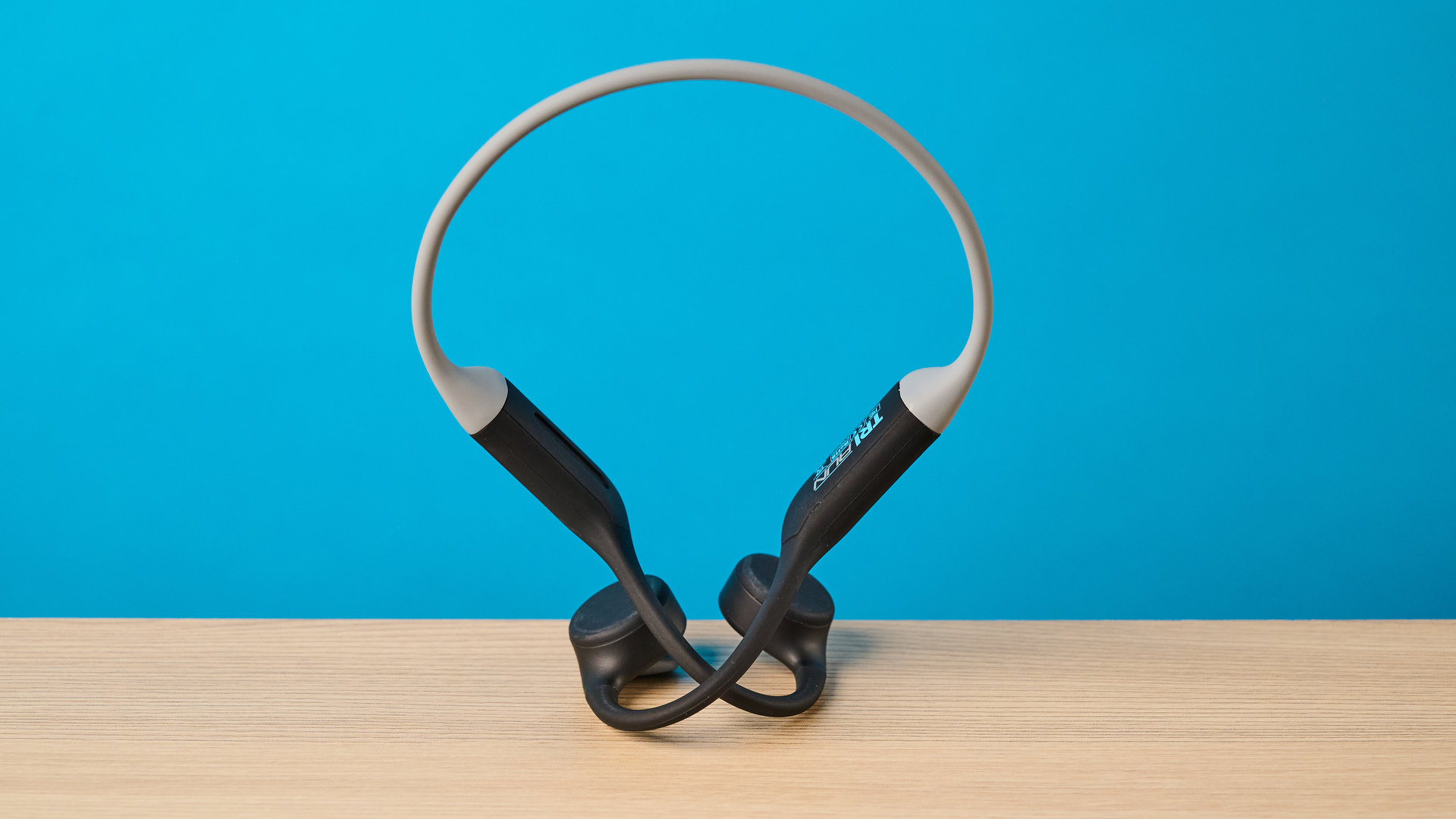 אוזניות ה-h2o audio tri run bone conduction שצולמו על רקע כחול של Tom's guide