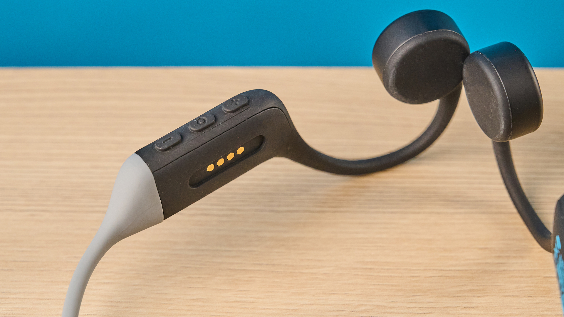 אוזניות ה-h2o audio tri run bone conduction שצולמו על רקע כחול של Tom's guide