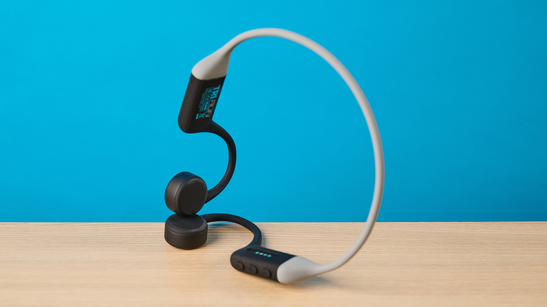 אוזניות ה-h2o audio tri run bone conduction שצולמו על רקע כחול של Tom's guide