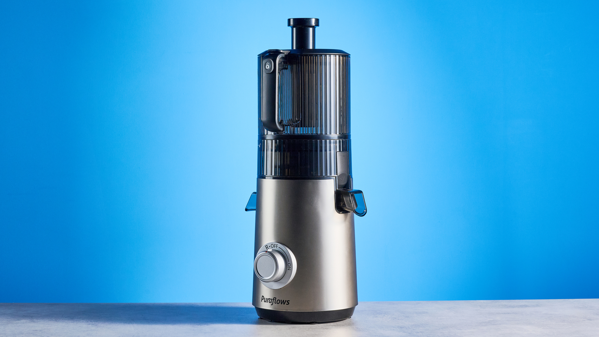 מסחטת מסחטת Puraflows Auramist Cold Press ואביזרים מצולמים מול רקע כחול