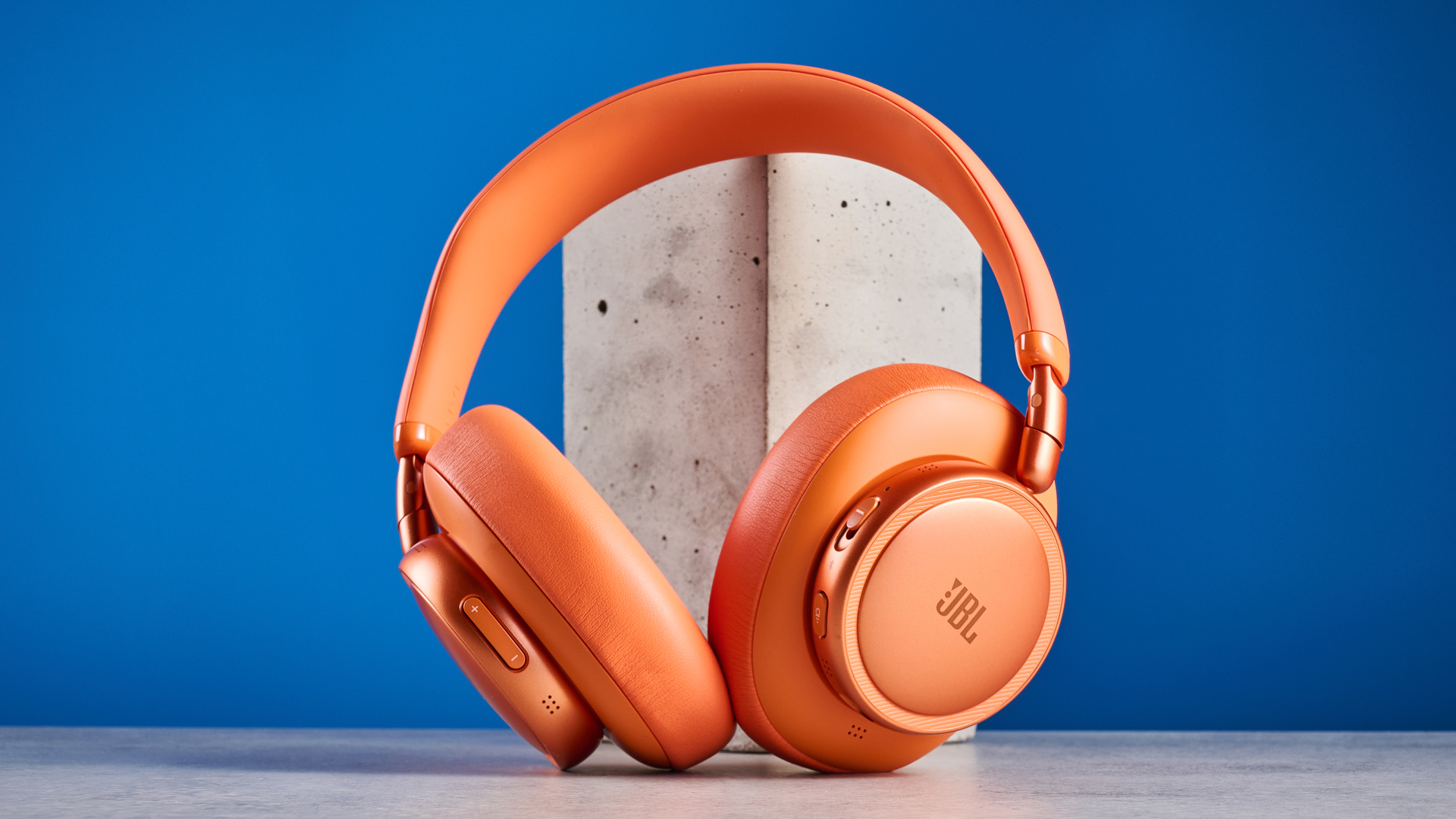 ה-jbl live 780NC בכתום שצולם על רקע המדריך הכחול
