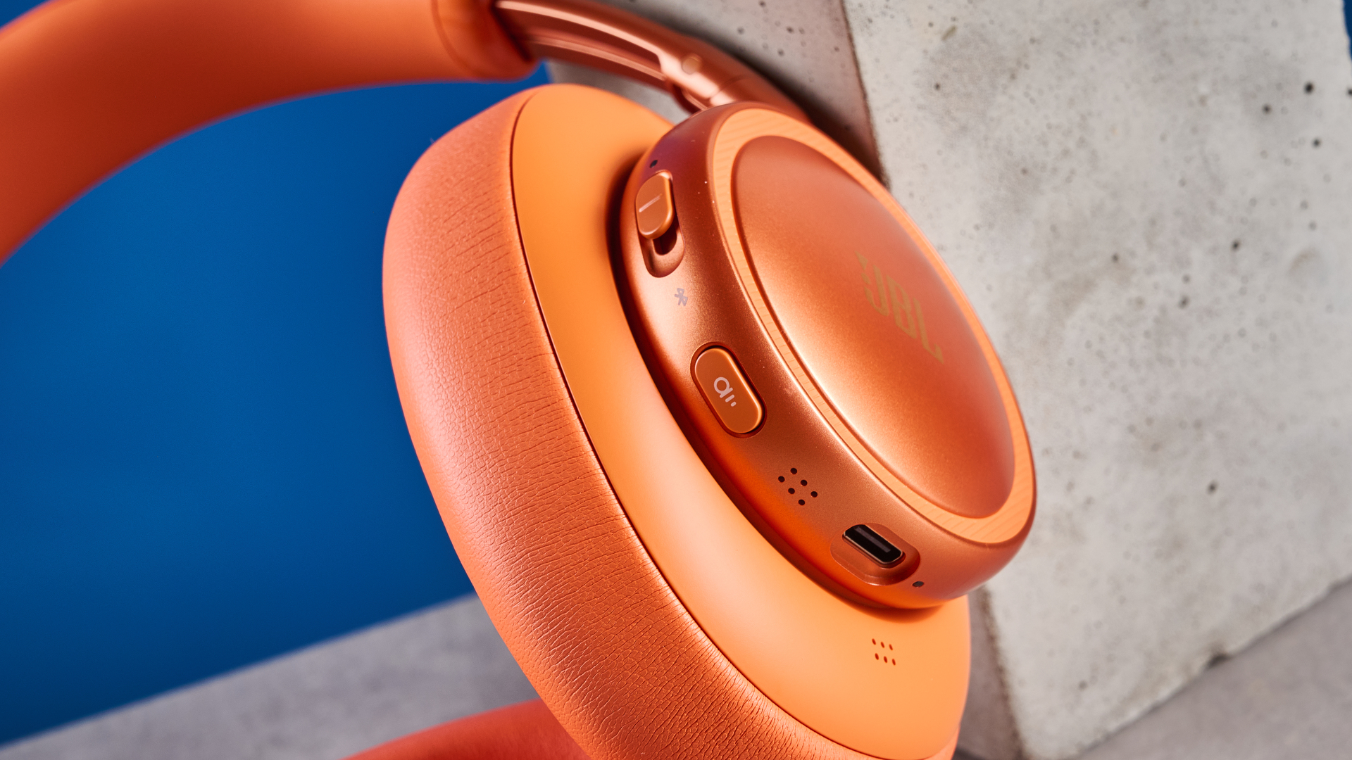 ה-jbl live 780NC בכתום שצולם על רקע המדריך הכחול