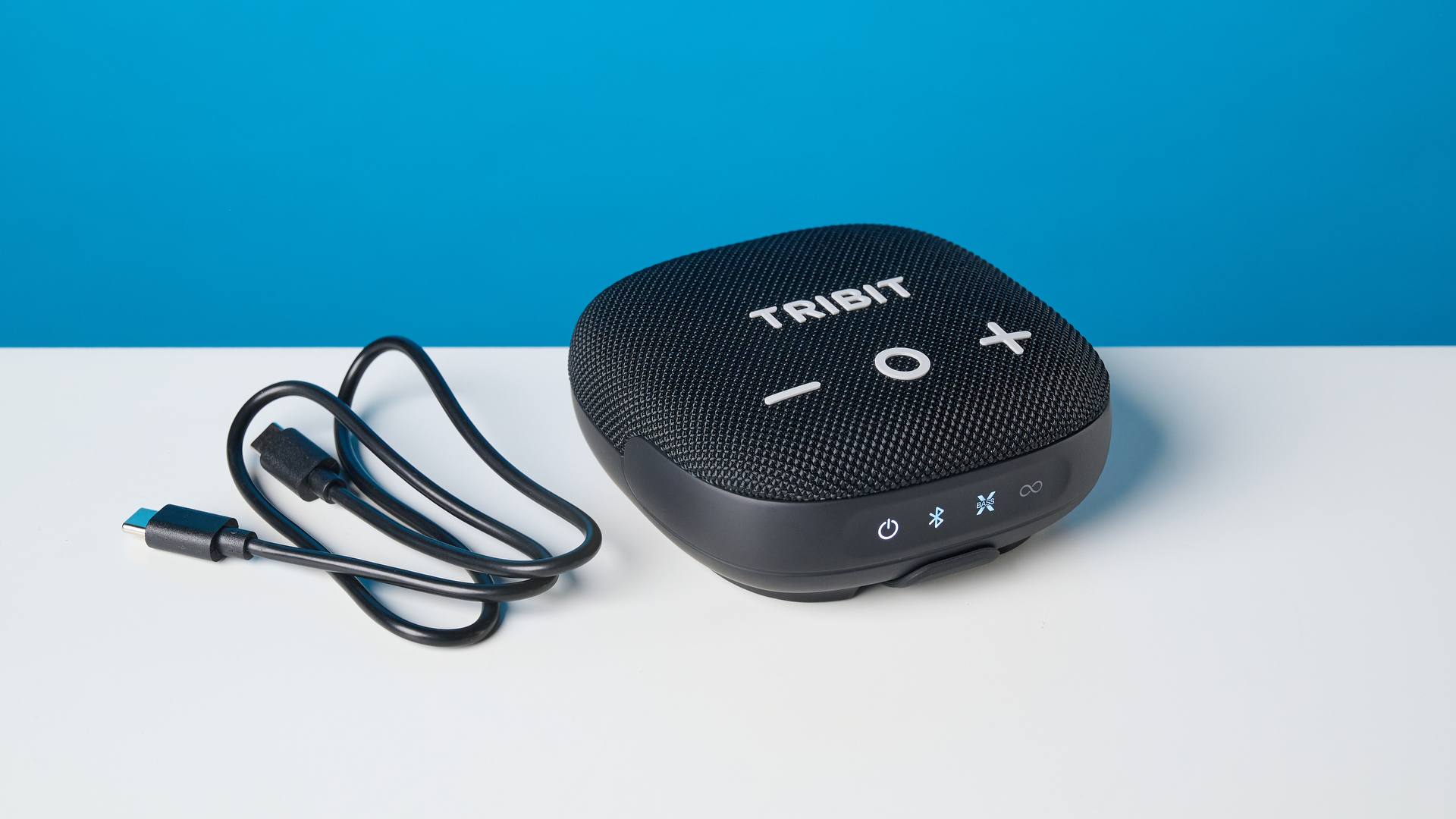 Tribit StormBox Micro 3 בצבע שחור מצולם מול רקע כחול