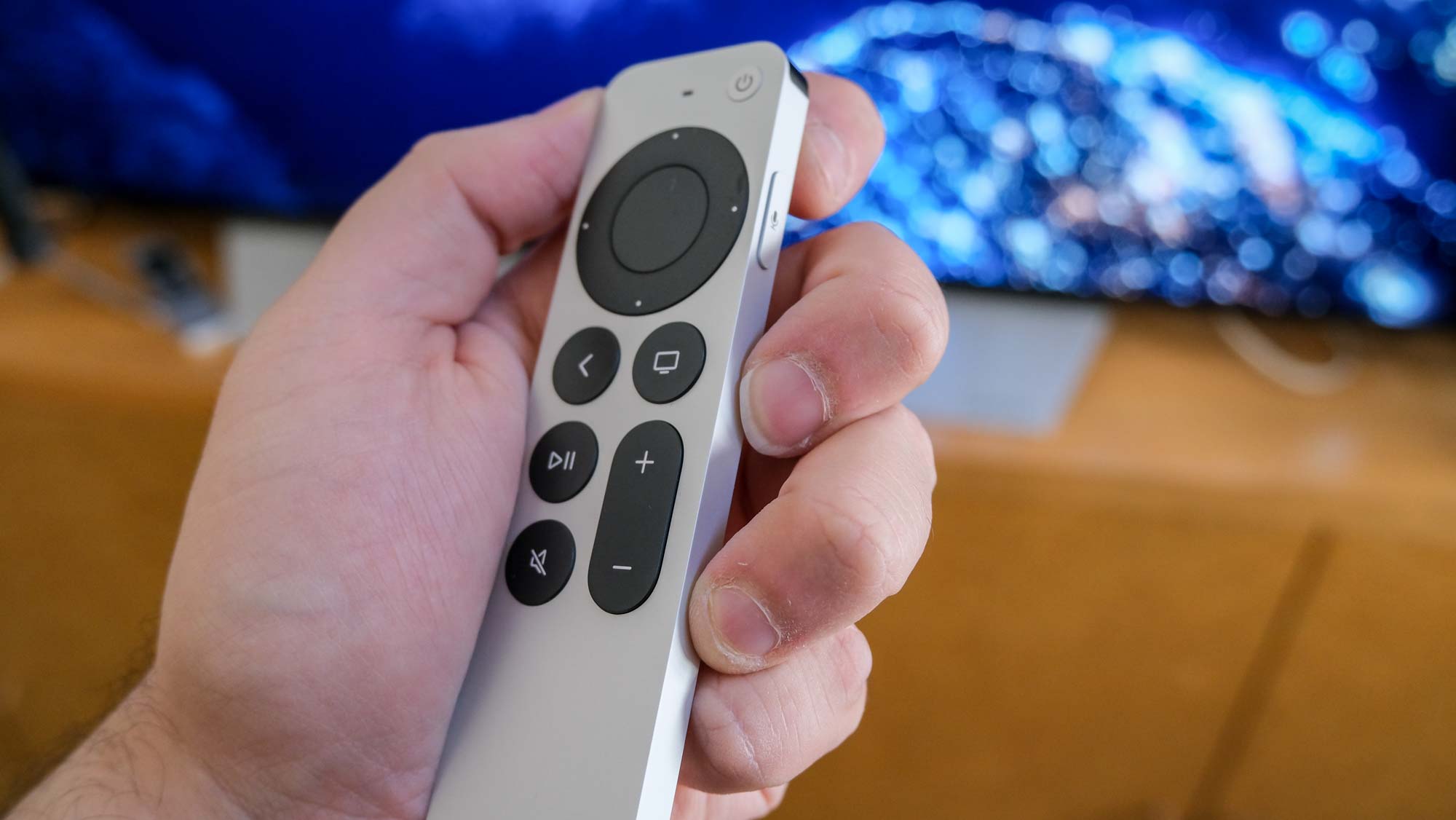 השלט של Apple TV 4K (2022) ביד, מוטה הצידה