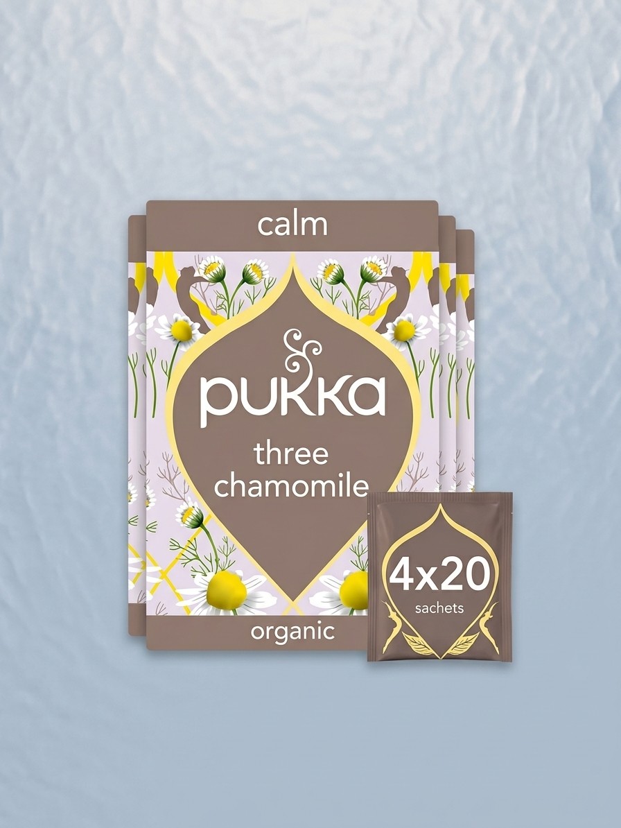 חבילות של Pukka שלוש שקיות תה קמומיל על רקע כחול בעריכת תאומים