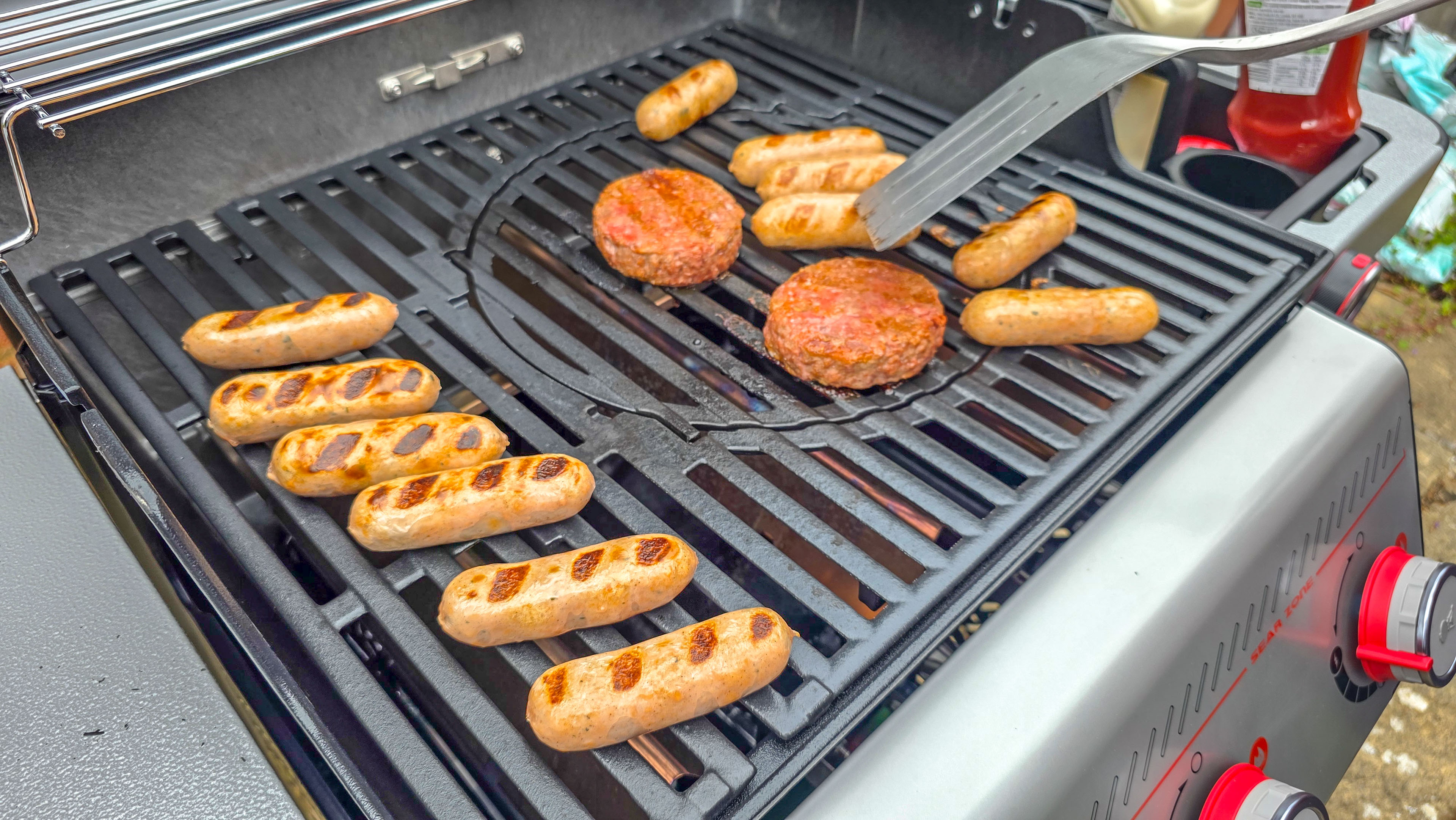 Weber Spirit EX325 צלייה של המבורגרים ונקניקיות