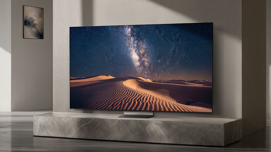 Samsung R95H בסלון בצבע אפור מציג את שביל החלב מעל דיונות חול במדבר 