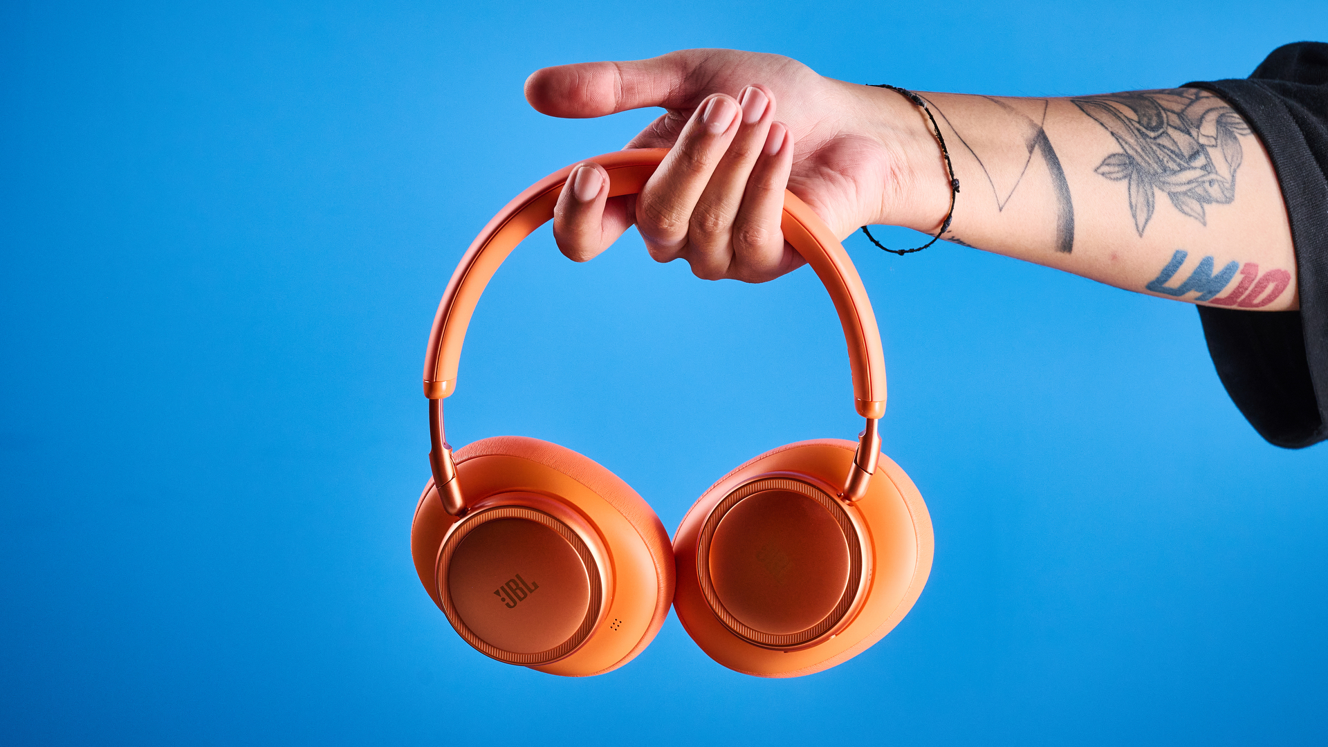 ה-jbl live 780NC בכתום שצולם על רקע המדריך הכחול