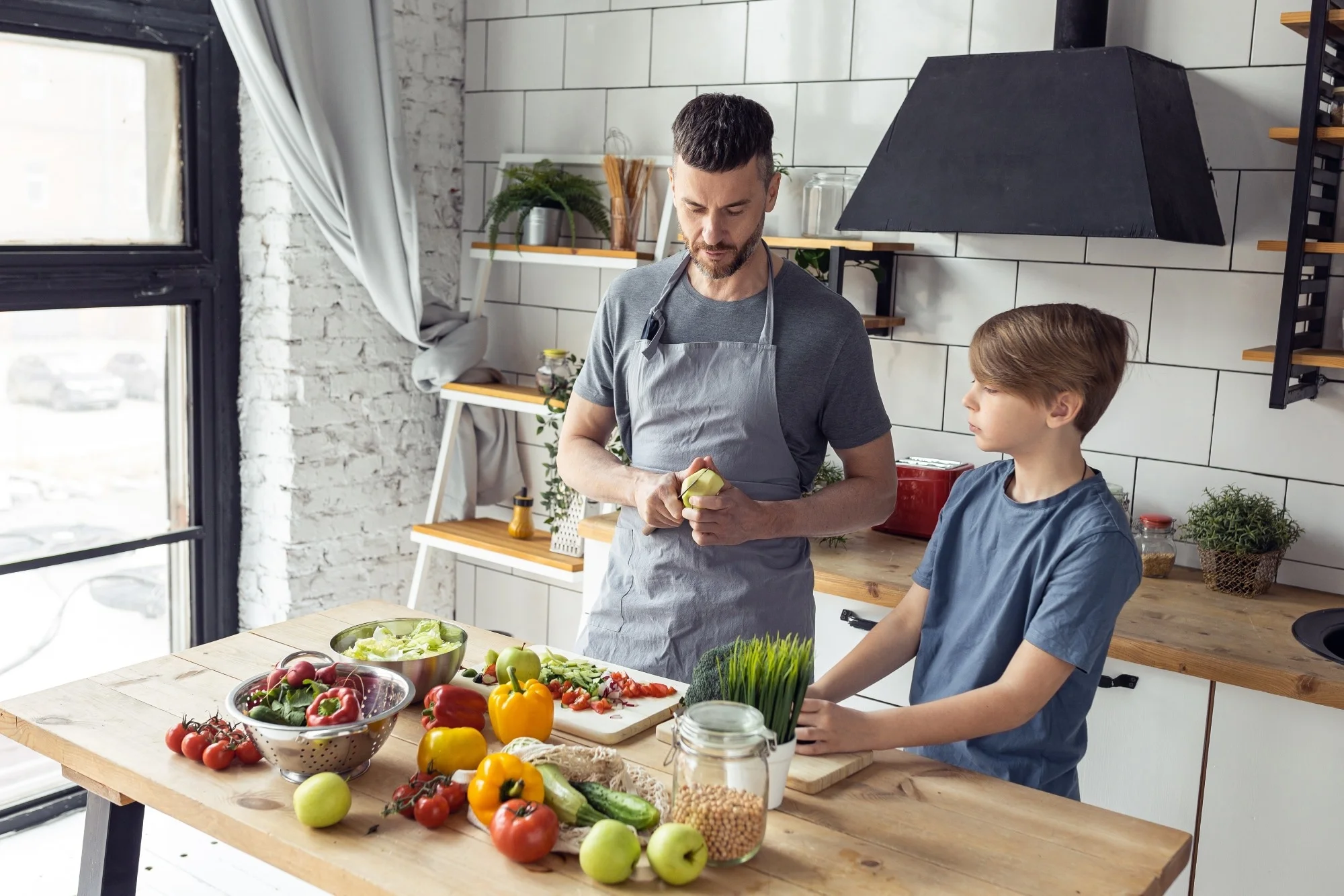 Father and son cooking vegetables in kitchen