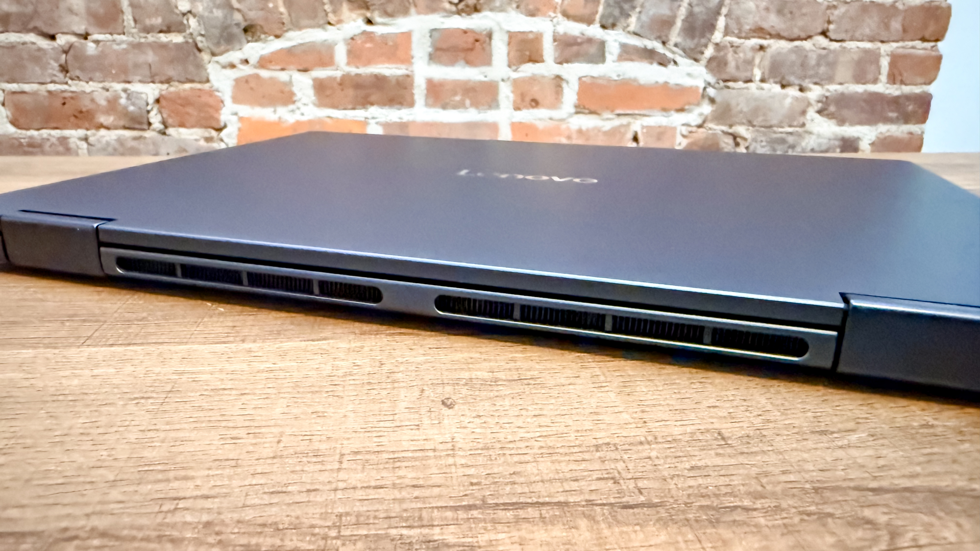 Lenovo Chromebook Plus 2-in-1 Gen 10 עם המכסה שלו סגור ומציג את הציר שלו על שולחן