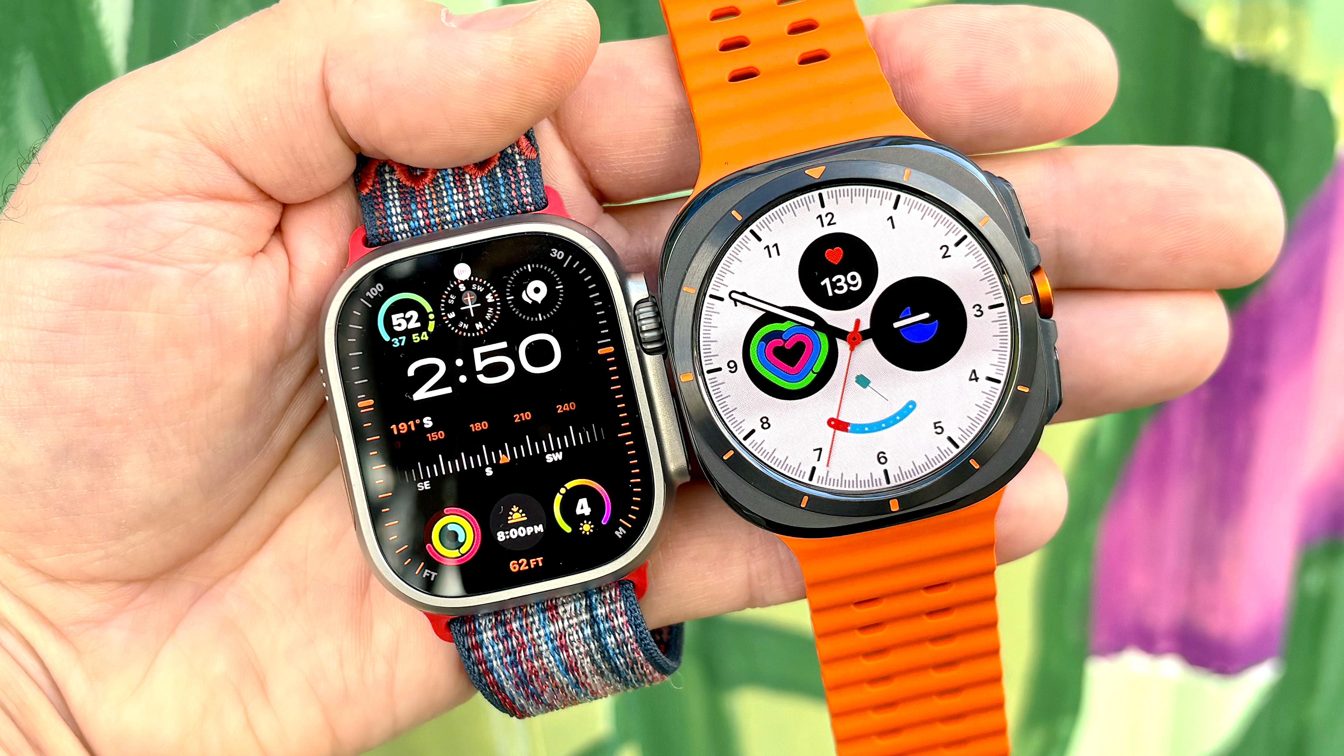 תקריב של ה-Apple Watch Ultra 3 ליד ה-Samsung Galaxy Watch Ultra ביד הסופר על רקע צבעוני