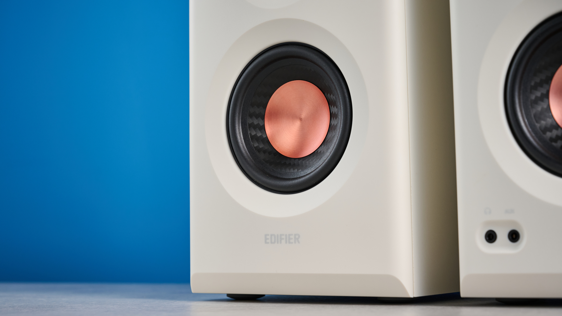 הסטודיו של Edifier MR5 מנטר רמקולי מדף ספרים שצולמו עם רקע המדריך הכחול